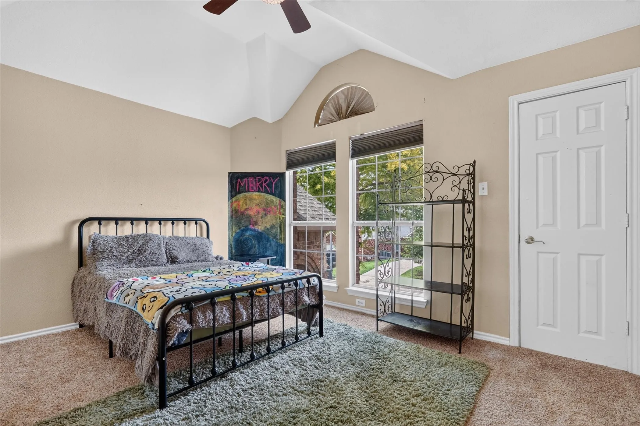 Vaulted ceiling with ceiling fan, dual large windows, and an arched transom window