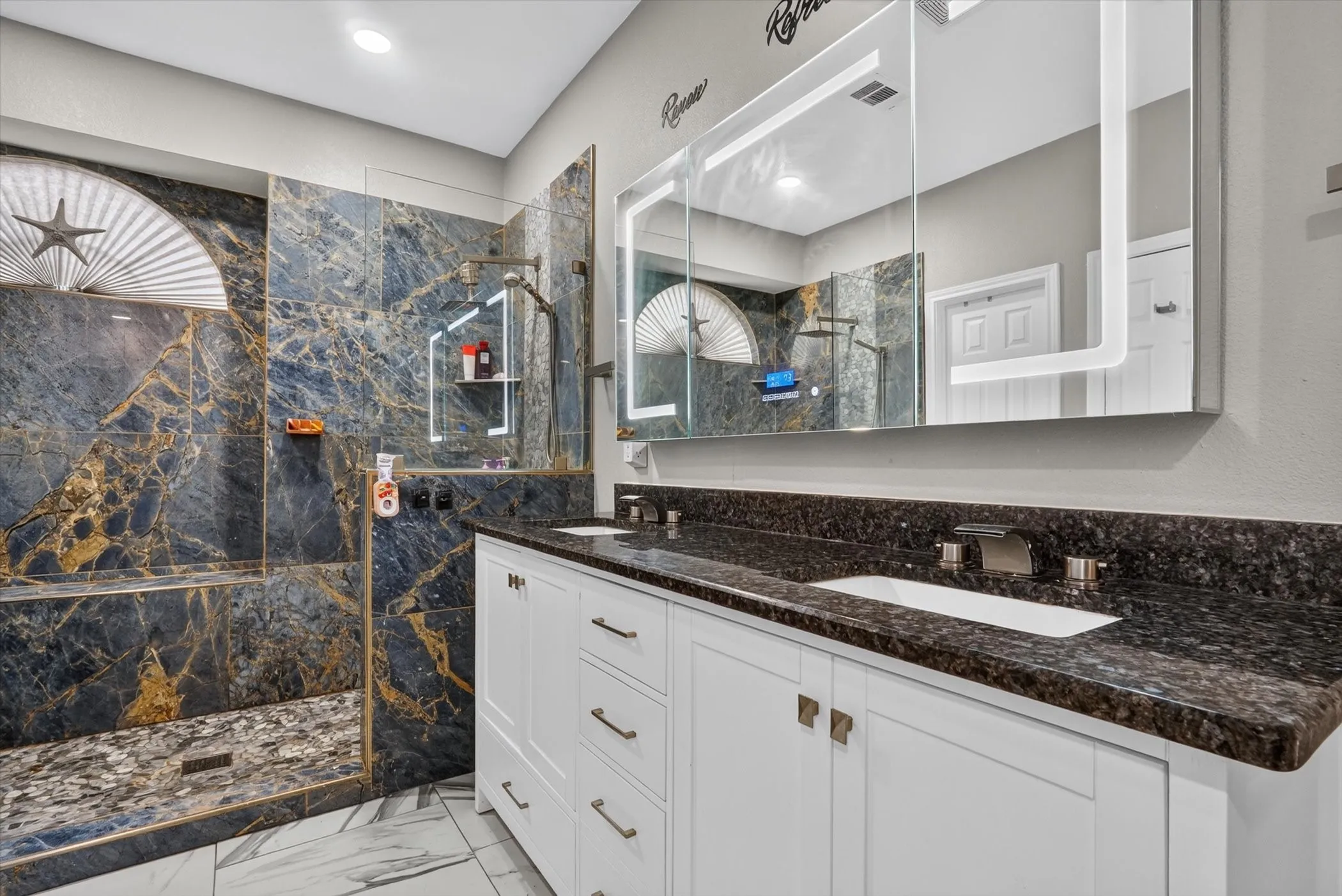 Walk-in shower featuring blue and gold veined tile, a glass enclosure, and a built-in bench
