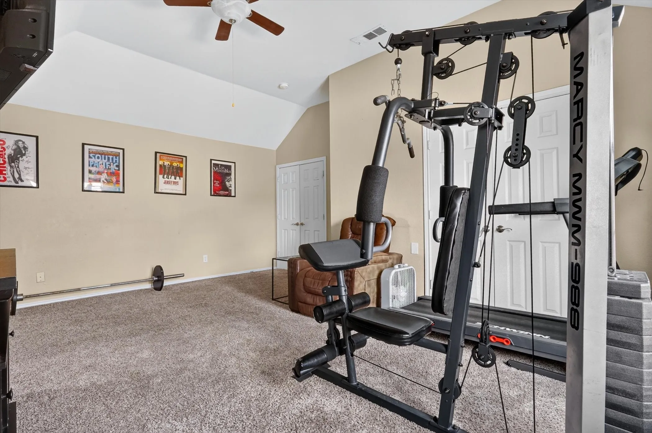 Carpeted room featuring a vaulted ceiling and a ceiling fan