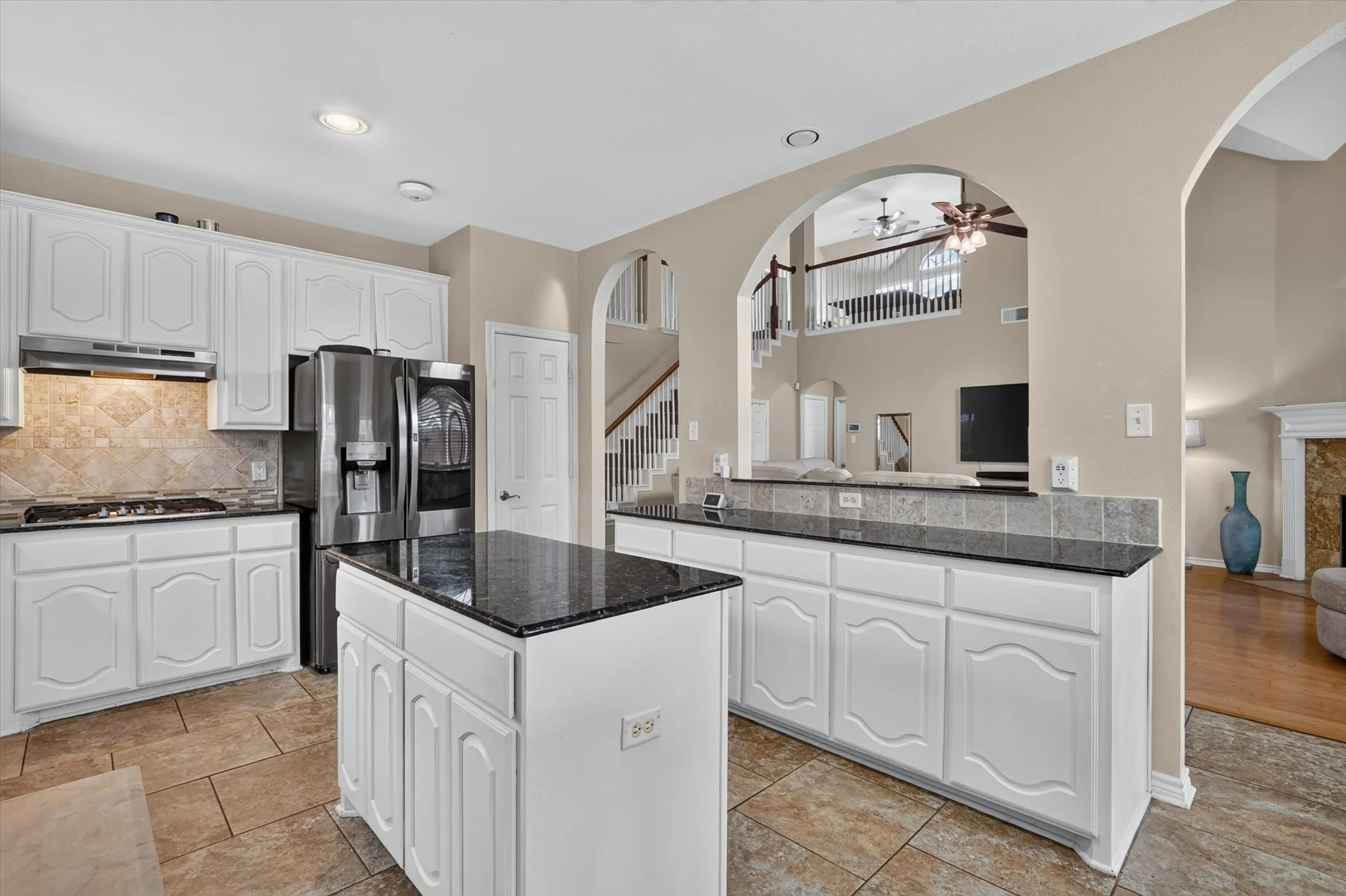 Well-appointed kitchen featuring white cabinetry, dark stone countertops, and stainless steel appliances