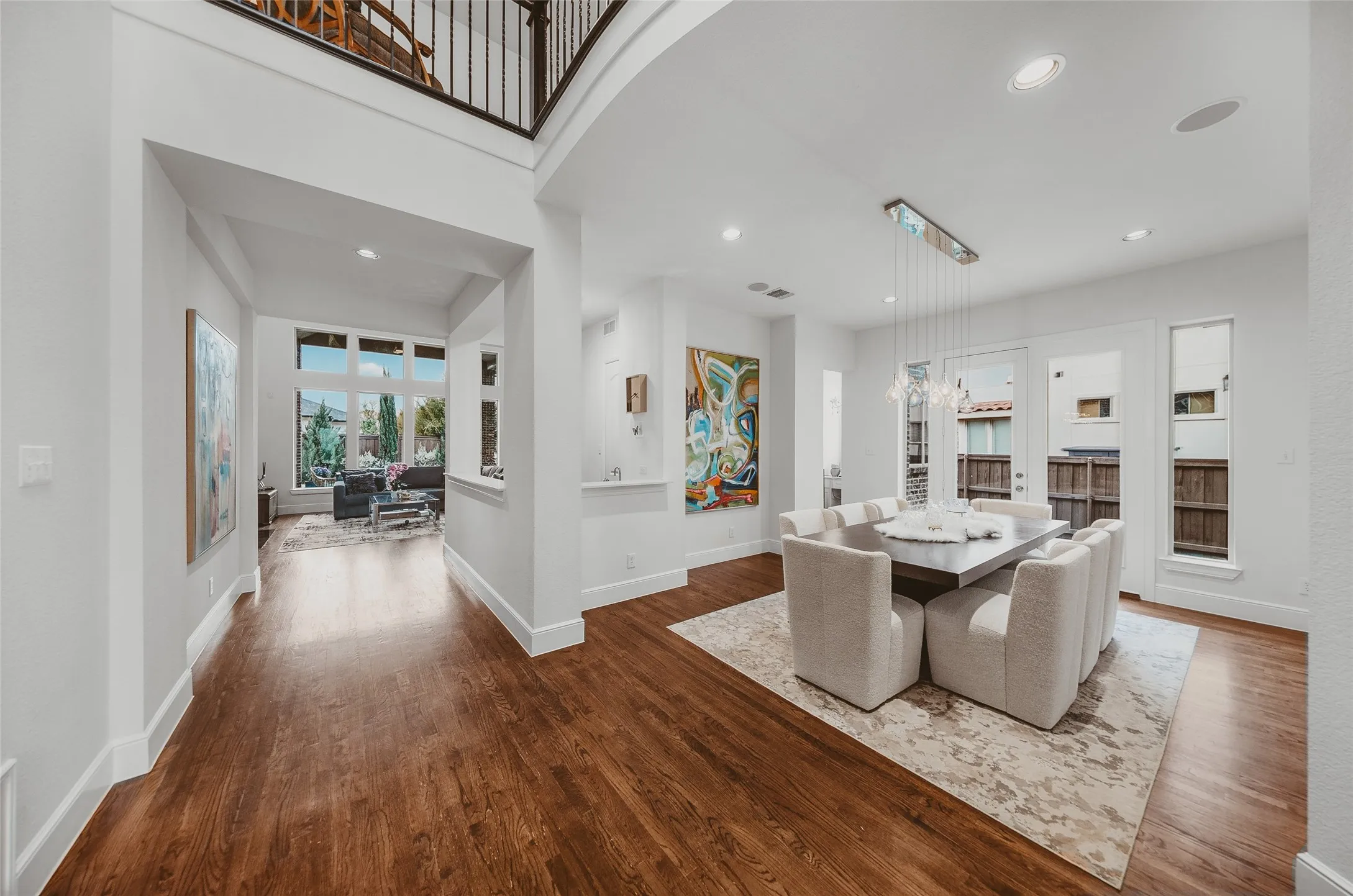Spacious dining area featuring hardwood flooring, recessed lighting, and a contemporary chandelier