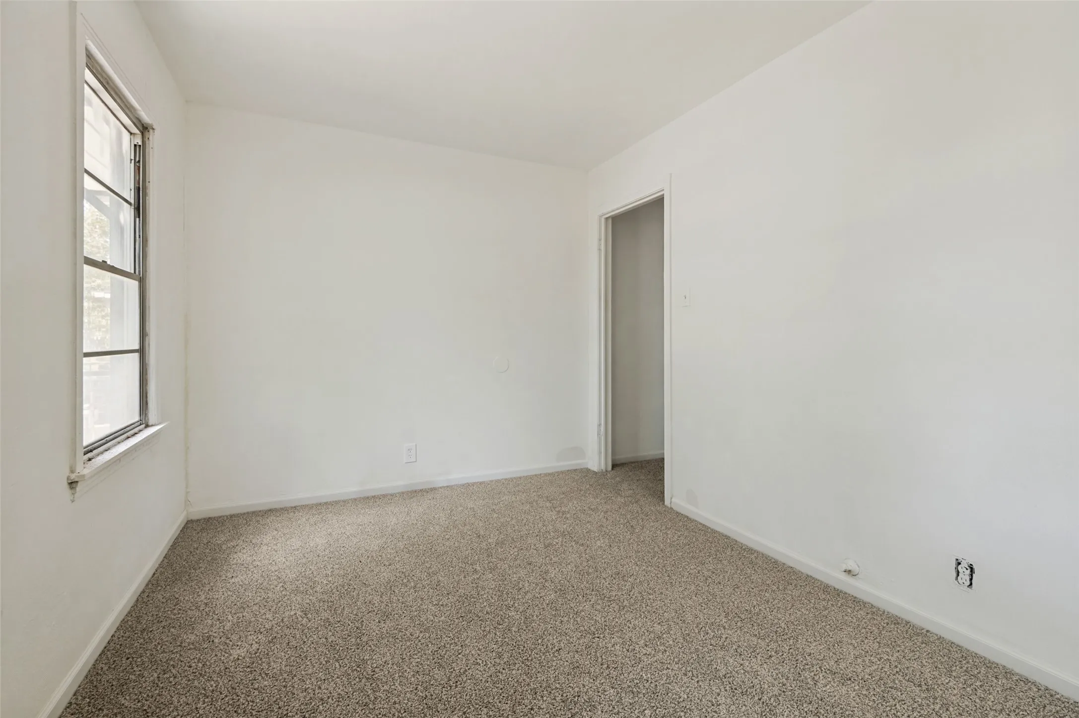 Room featuring light-colored walls and speckled carpeting