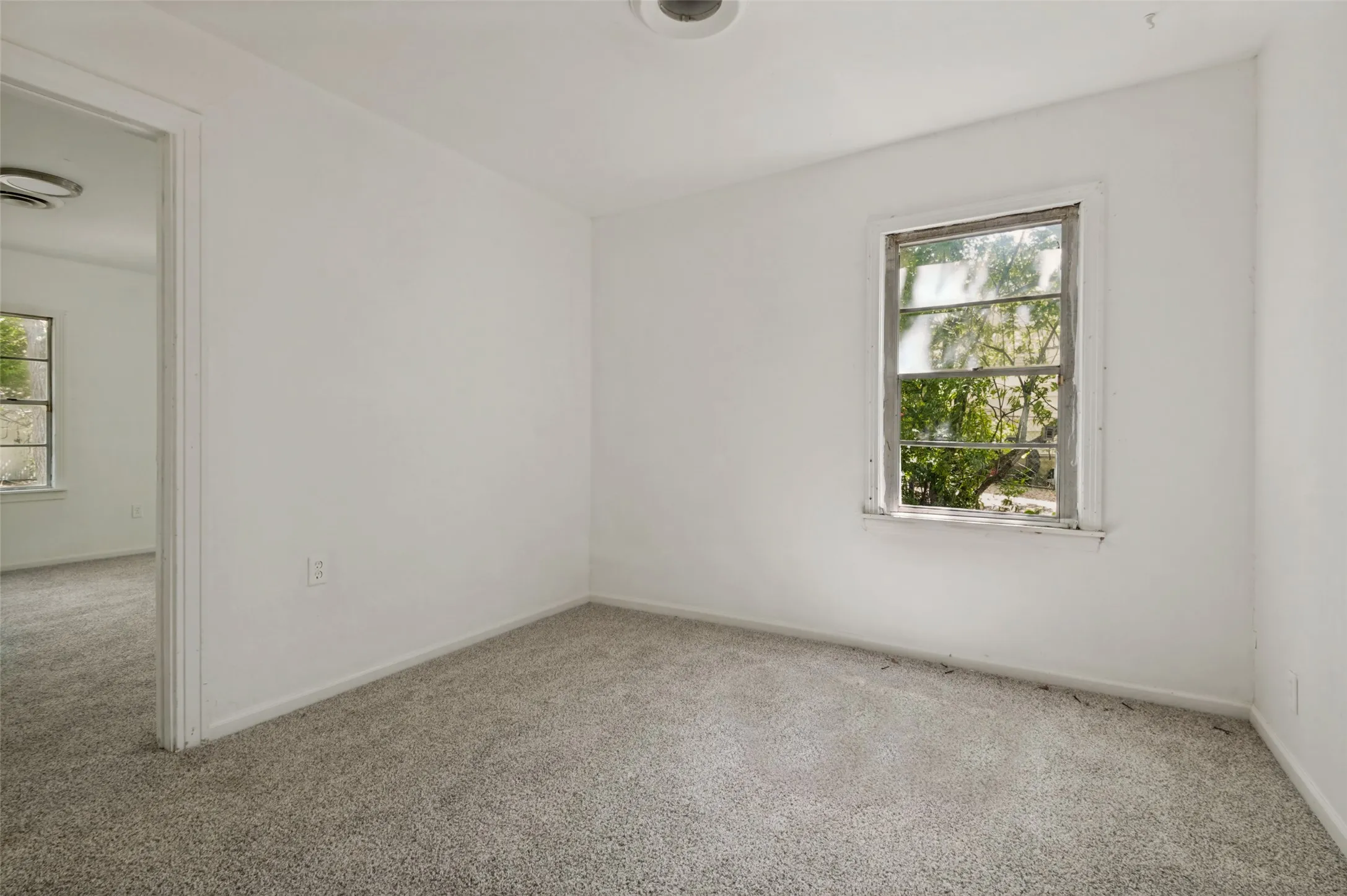 Room featuring light gray carpet, white walls, a single window, and a white ceiling light fixture