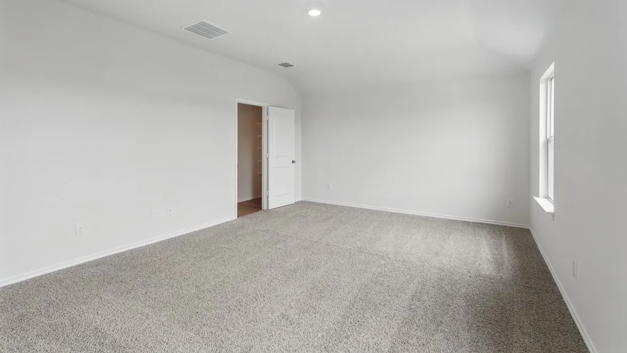 Spacious room featuring light gray carpeting, white walls, a single window, an open closet, and recessed lighting