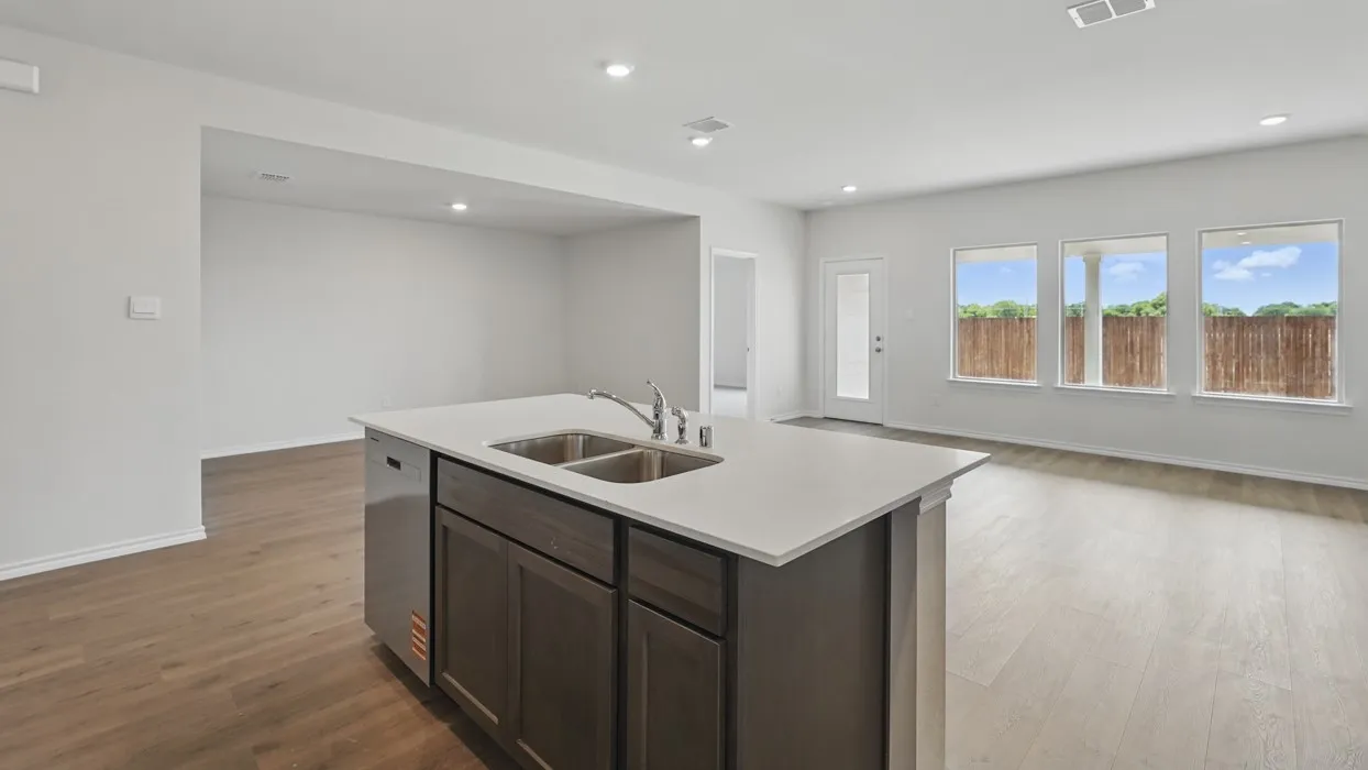 Central kitchen island with an undermount double-basin sink and a white countertop
