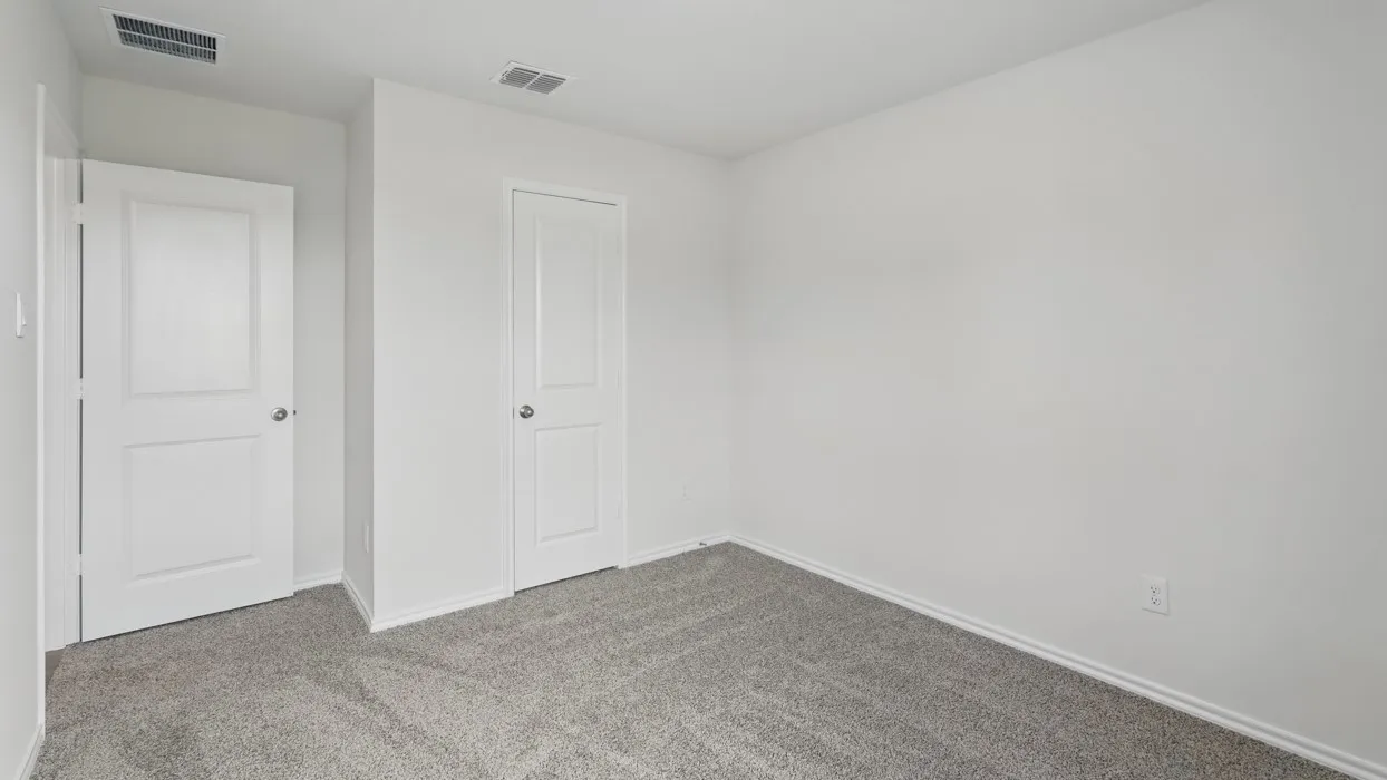 Interior space featuring light gray carpet, white baseboards, and two white two-panel doors