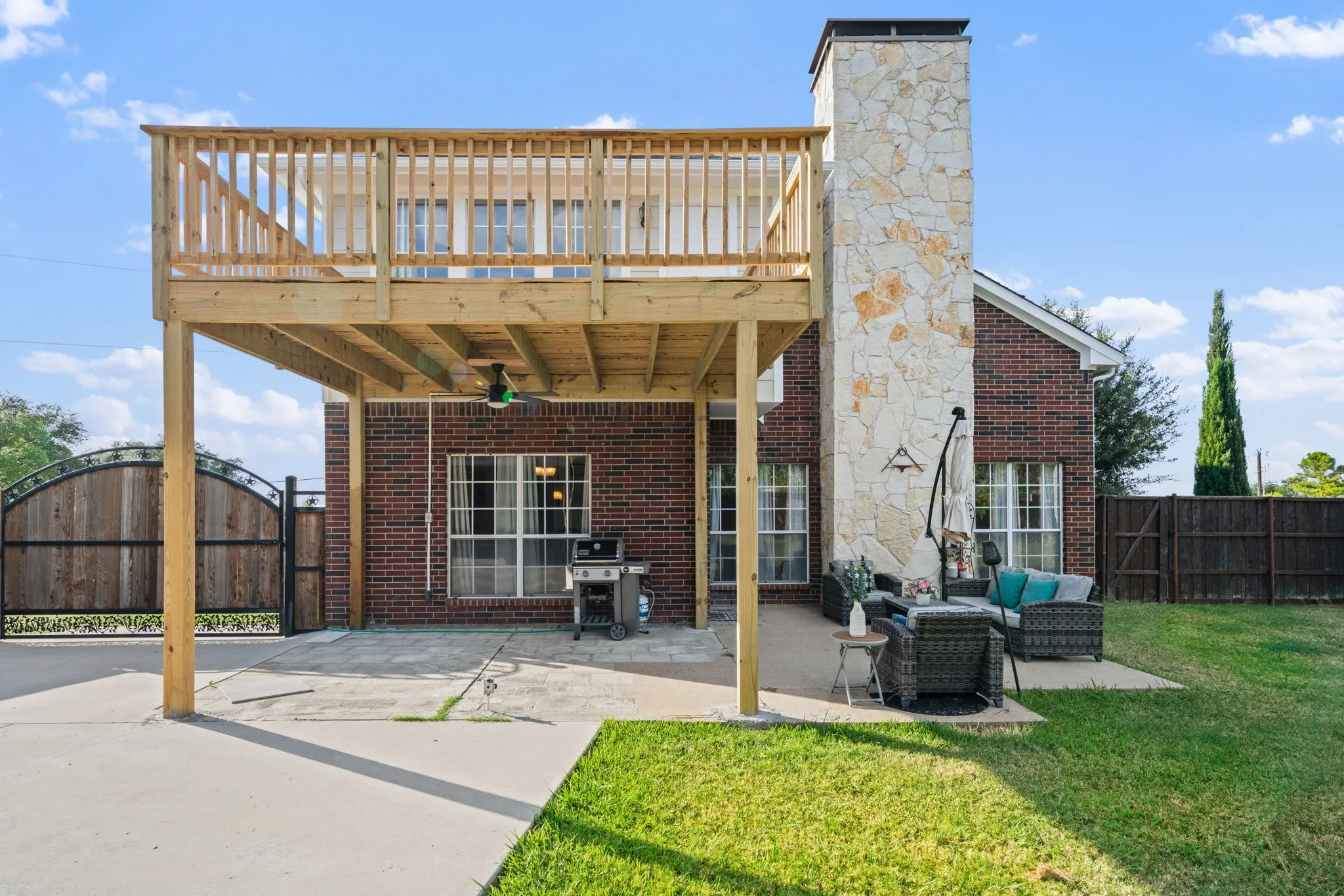 Brick exterior with a stone chimney, featuring a spacious elevated wood deck