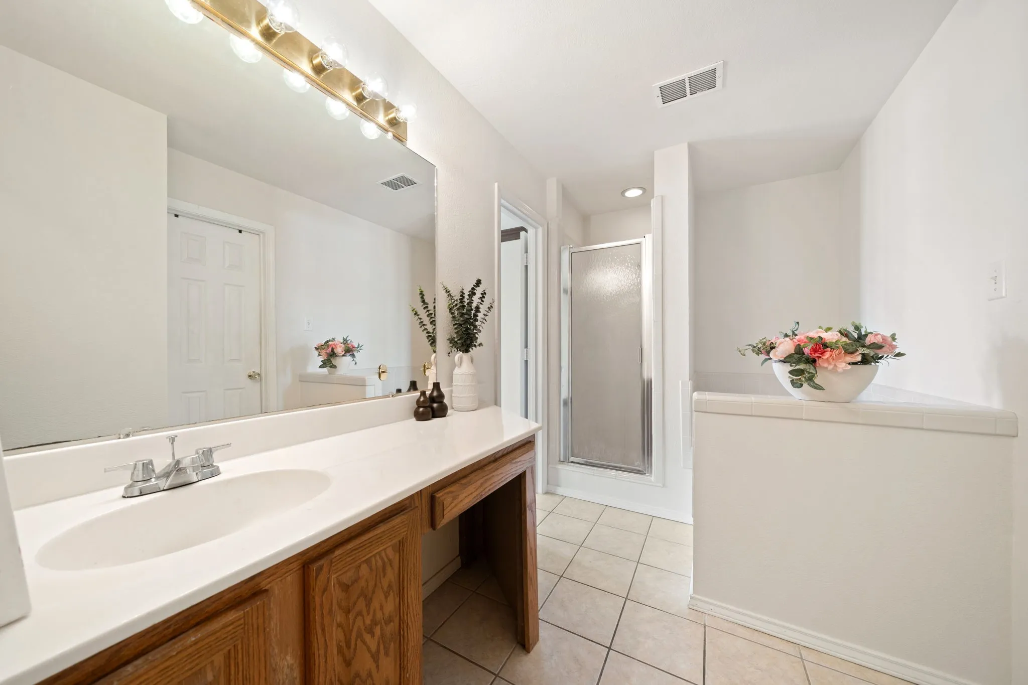 PrimaryBathroom featuring a single vanity with a white countertop and a built-in oval sink
