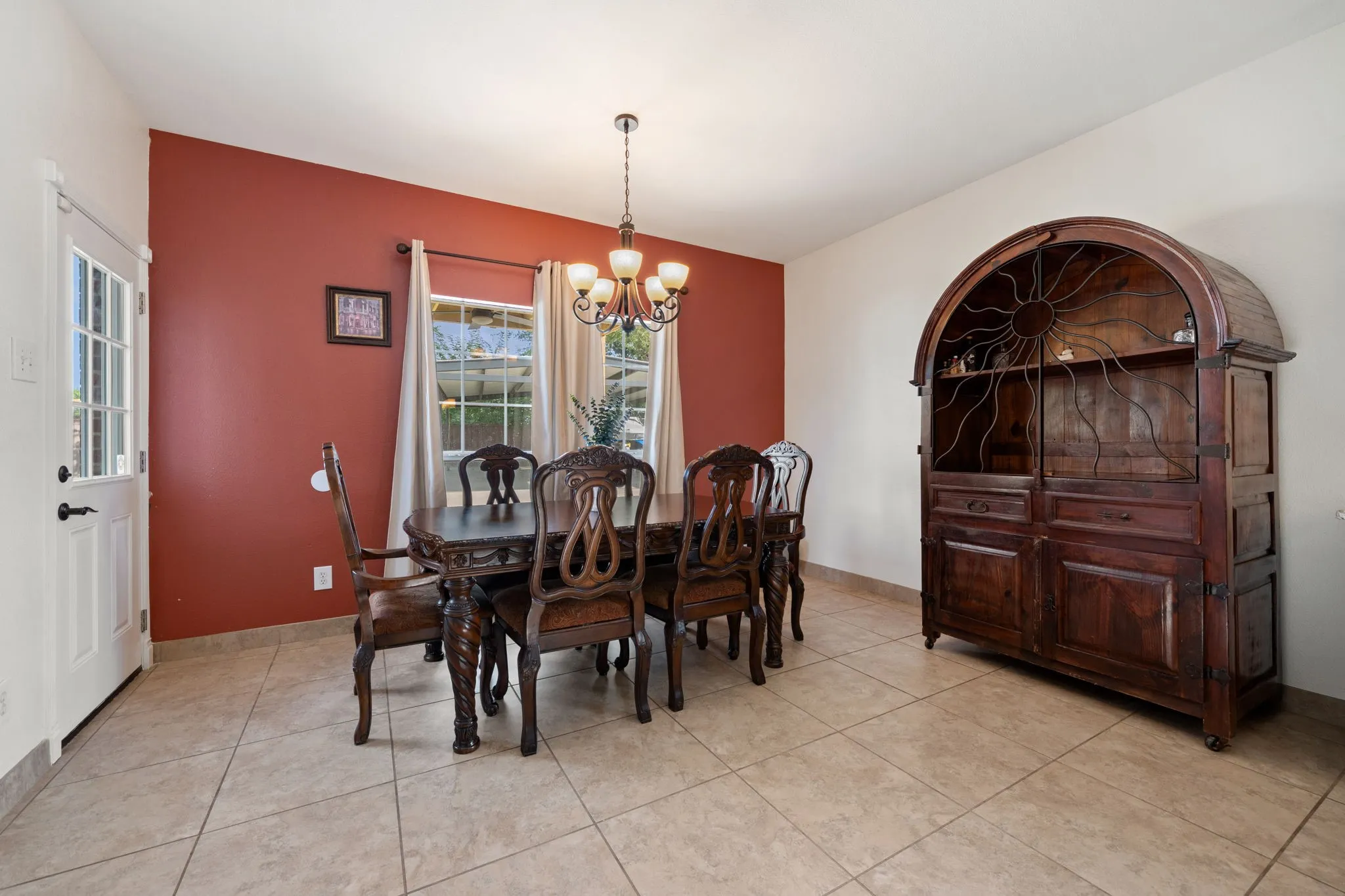 Dining area featuring tile flooring, a multi-pane glass door, and two windows with white trim