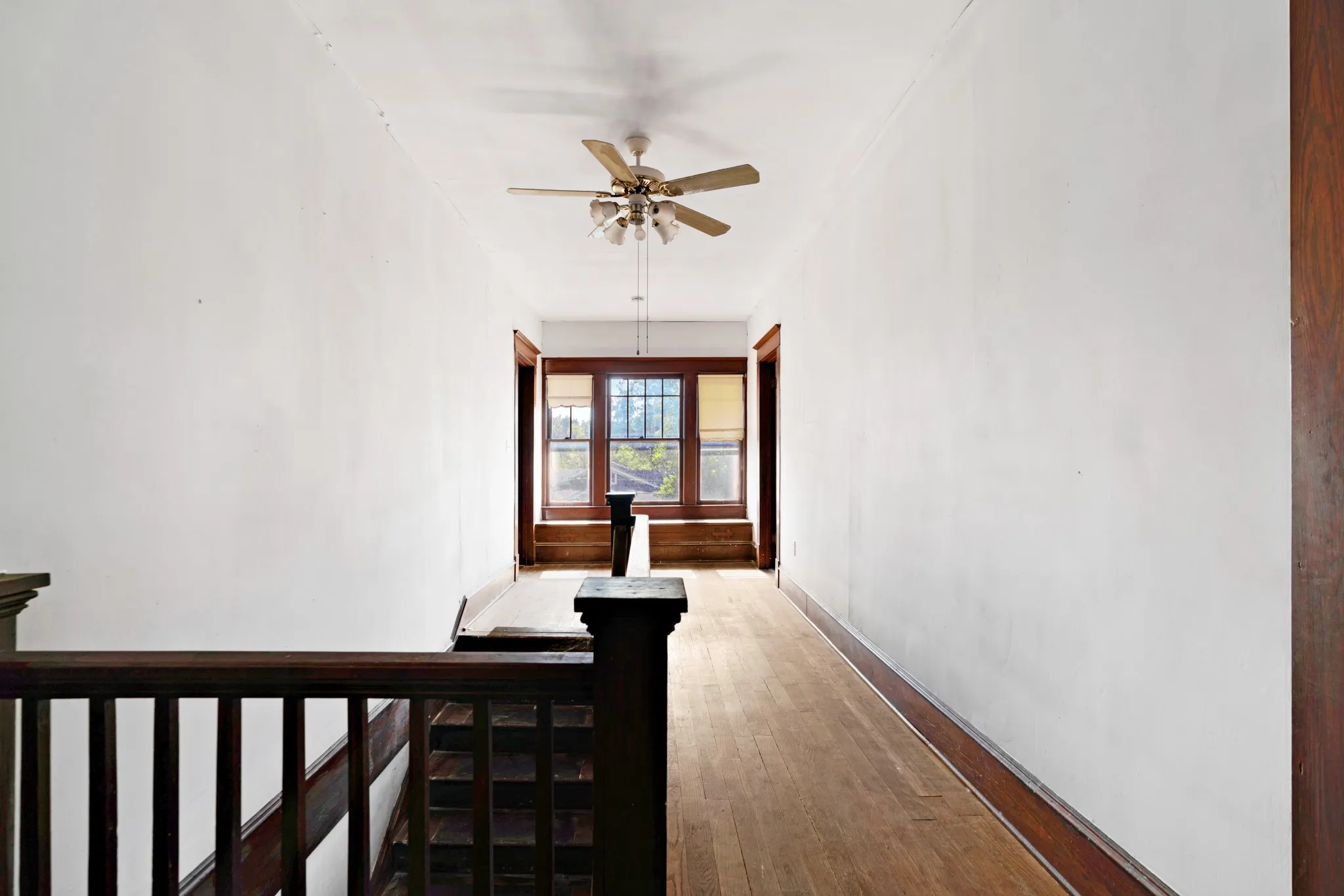 Hallway featuring wood-finish flooring and a ceiling fan