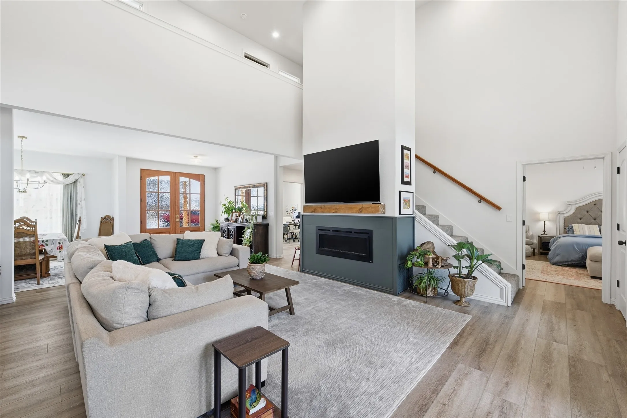 Vaulted living area featuring wood-finish flooring and a stone fireplace with a floating wood mantel
