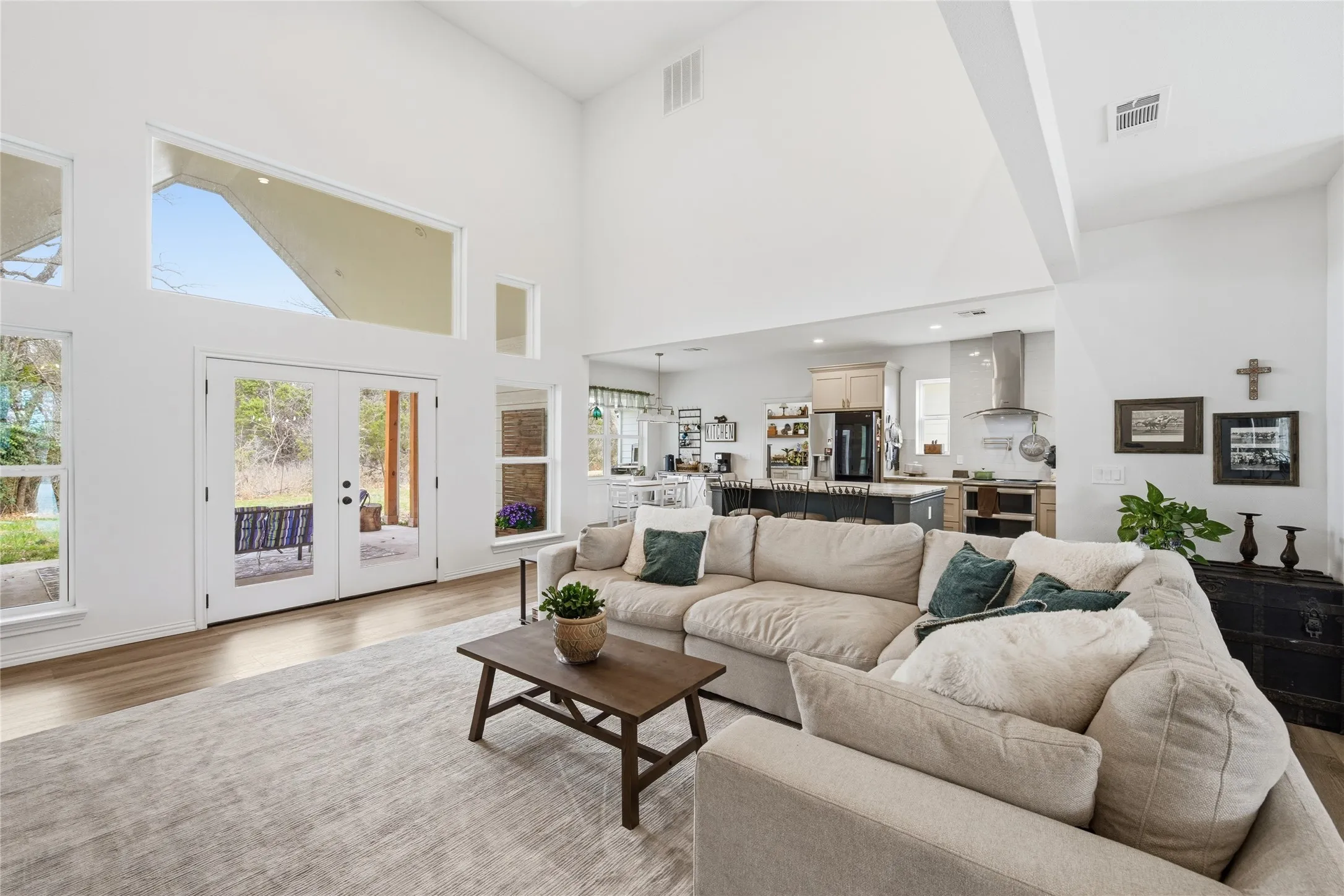 Spacious living area featuring high vaulted ceilings and wood-finish flooring