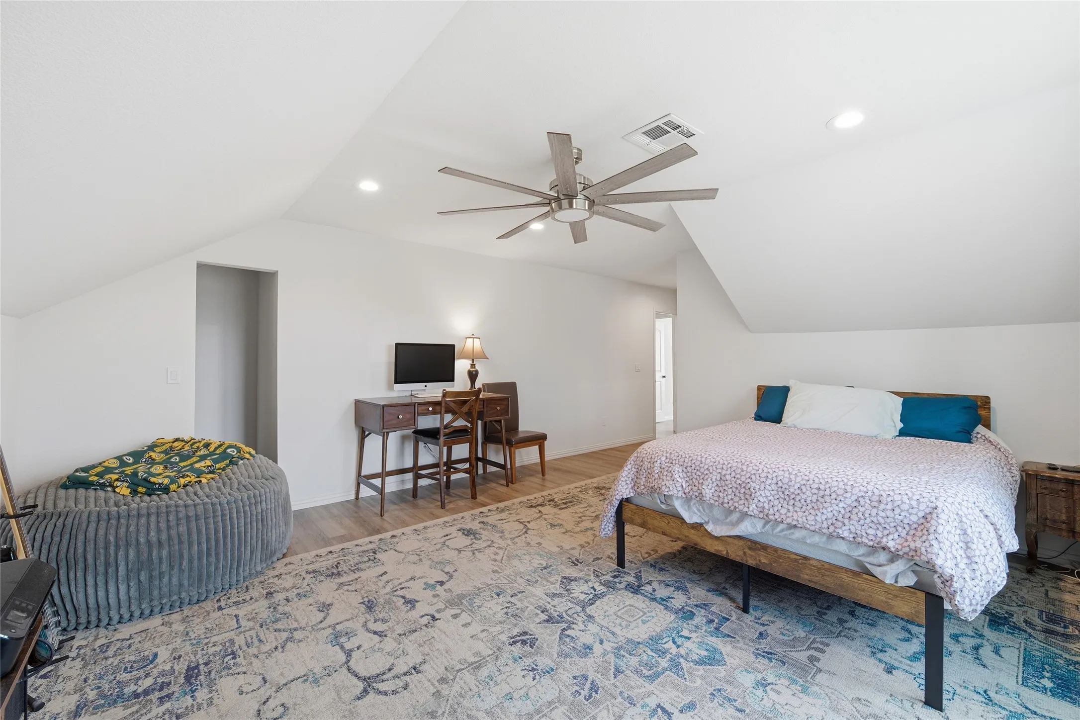 Vaulted ceilings with recessed lighting and a ceiling fan