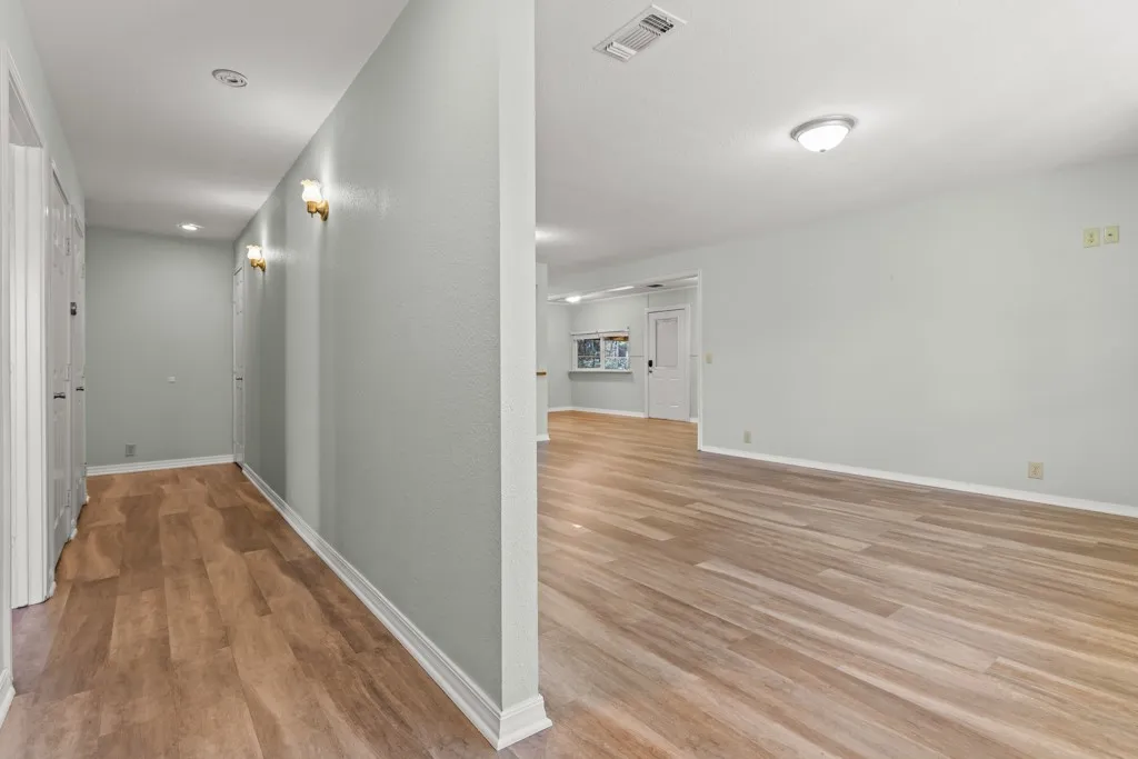 Open living space featuring wood-finish flooring and light-toned walls