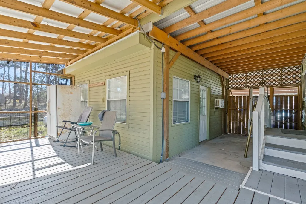 Covered outdoor patio area featuring a light green siding exterior