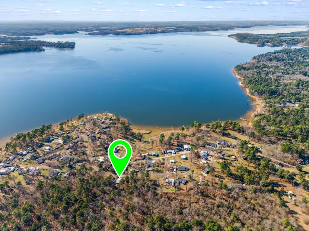 Expansive waterfront property with direct access to the lake, featuring a private dock and mature tree coverage