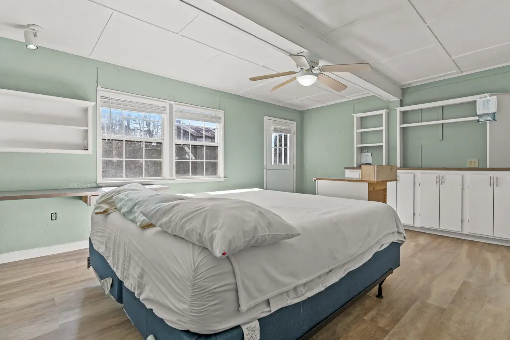 Room featuring light green walls and wood-finish flooring