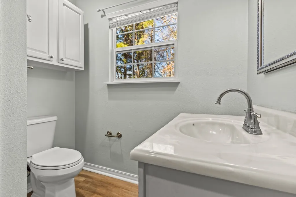 Vanity with integrated sink, chrome faucet, and framed mirror