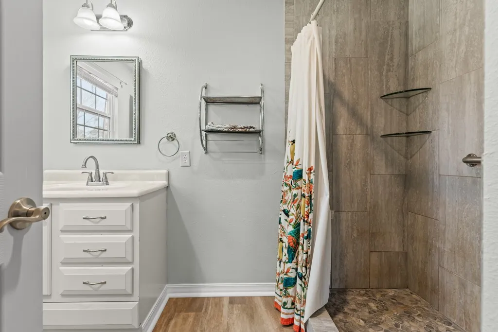 Contemporary bathroom featuring a single vanity with a white countertop, three drawer storage, and a chrome faucet