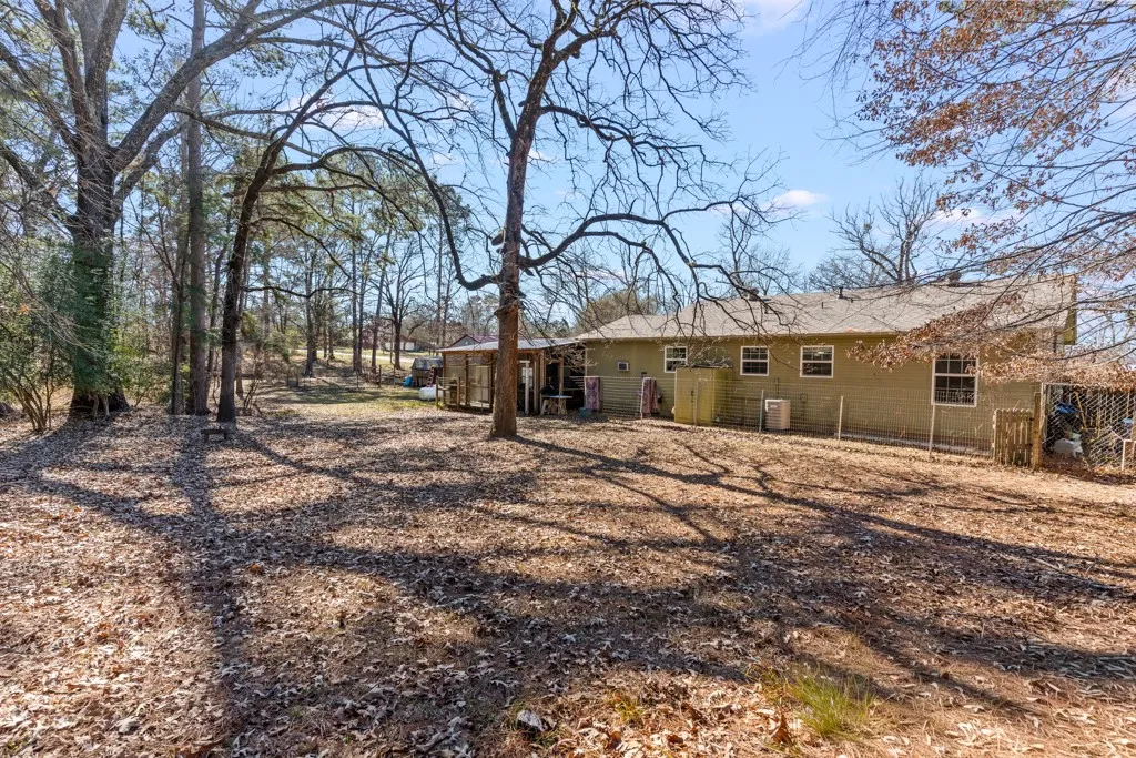 Spacious backyard with mature trees providing ample shade and a natural setting