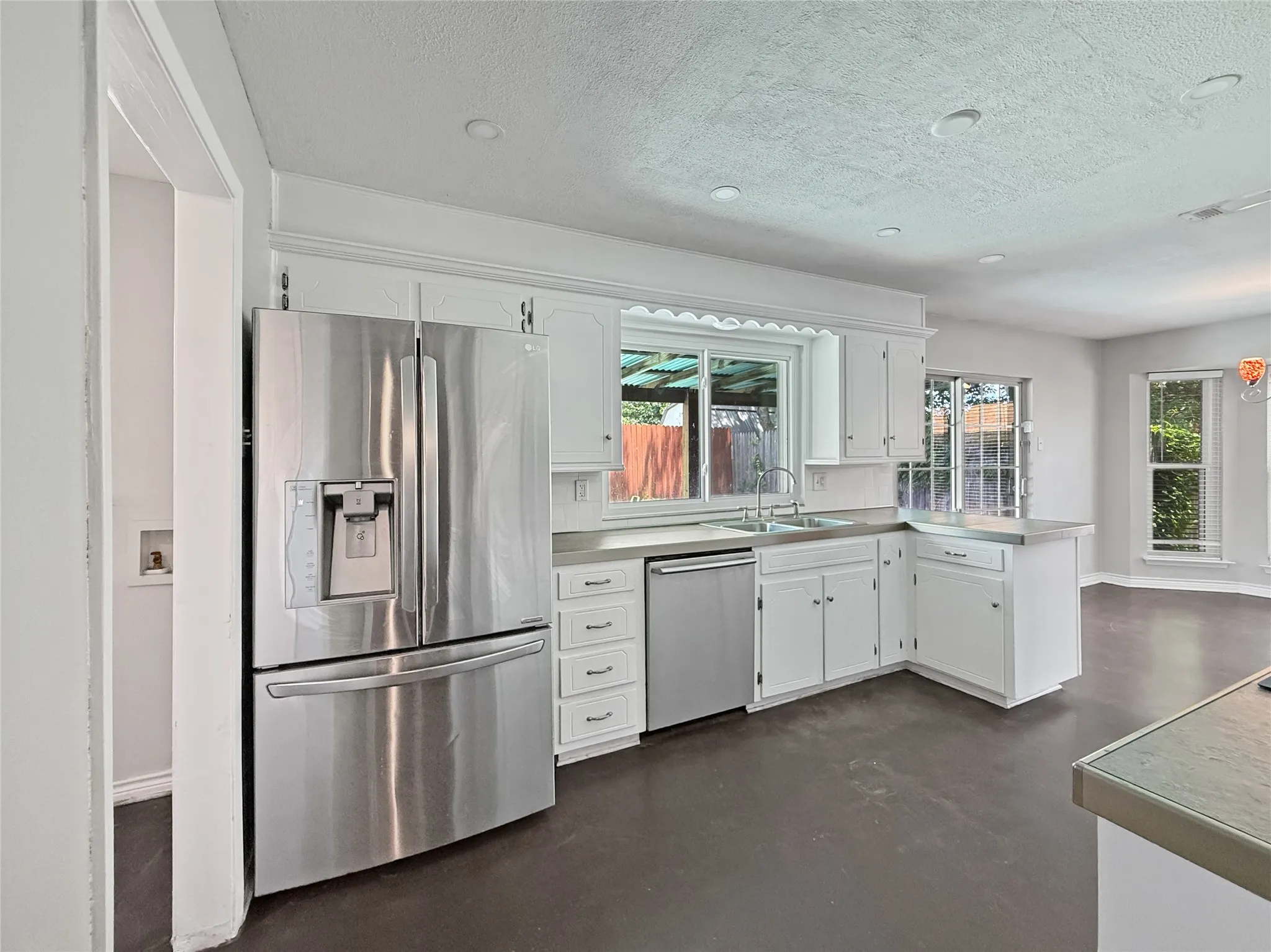 Kitchen featuring white cabinetry, stainless steel appliances, and a double basin sink