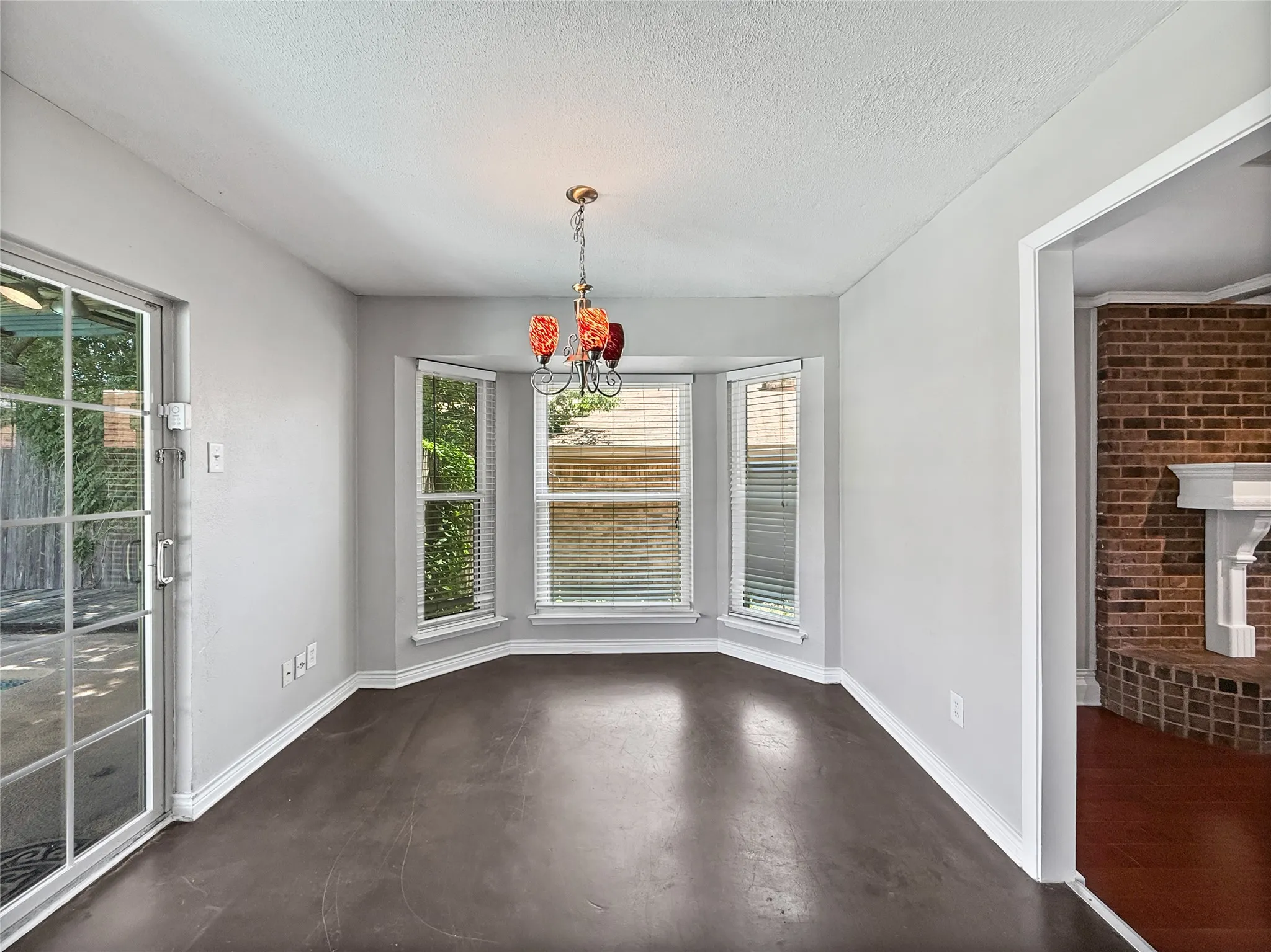 Dining area featuring a bay window, a modern chandelier, and light gray walls with white trim