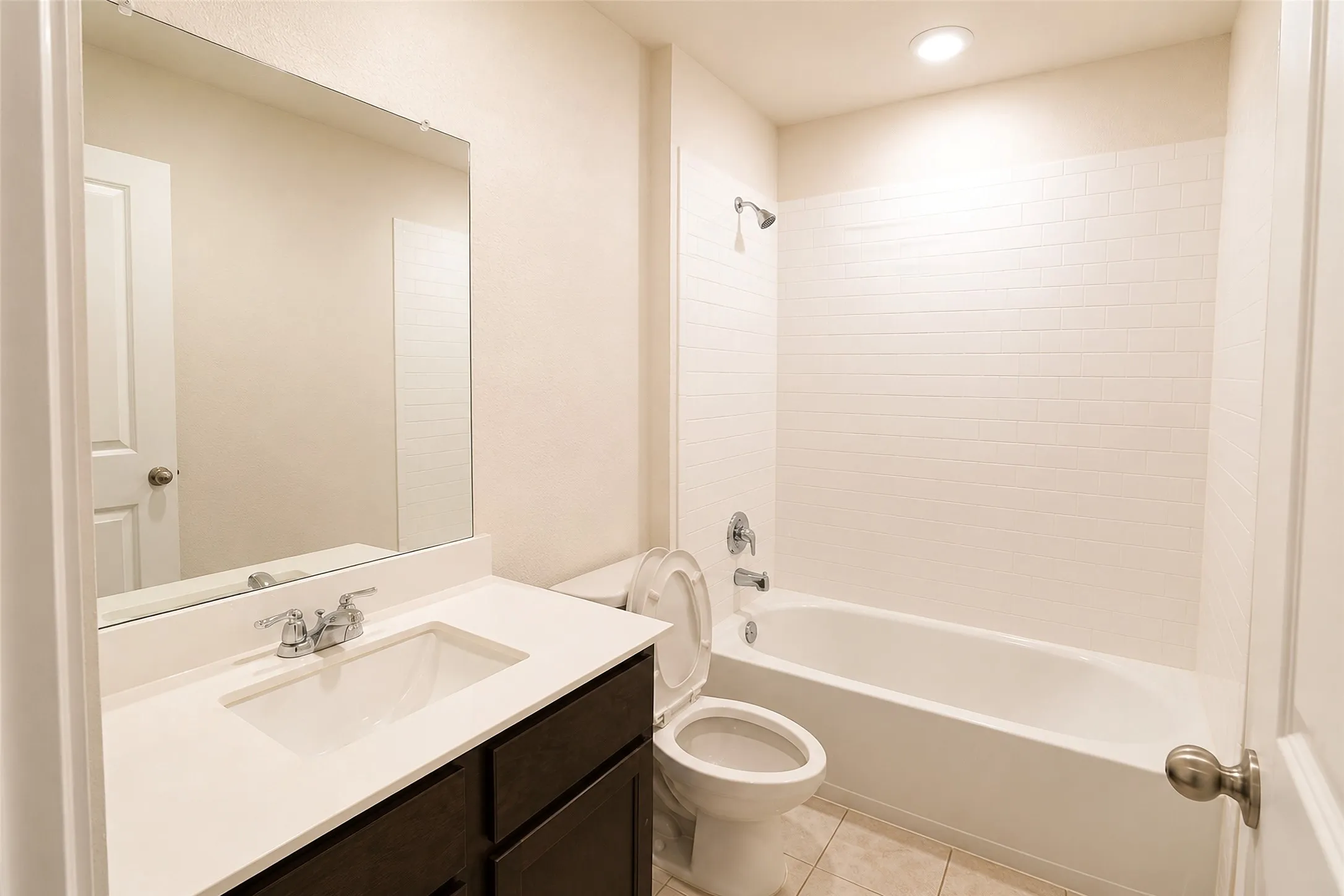 Bathroom featuring a dark wood-finish vanity with a white countertop and integrated sink