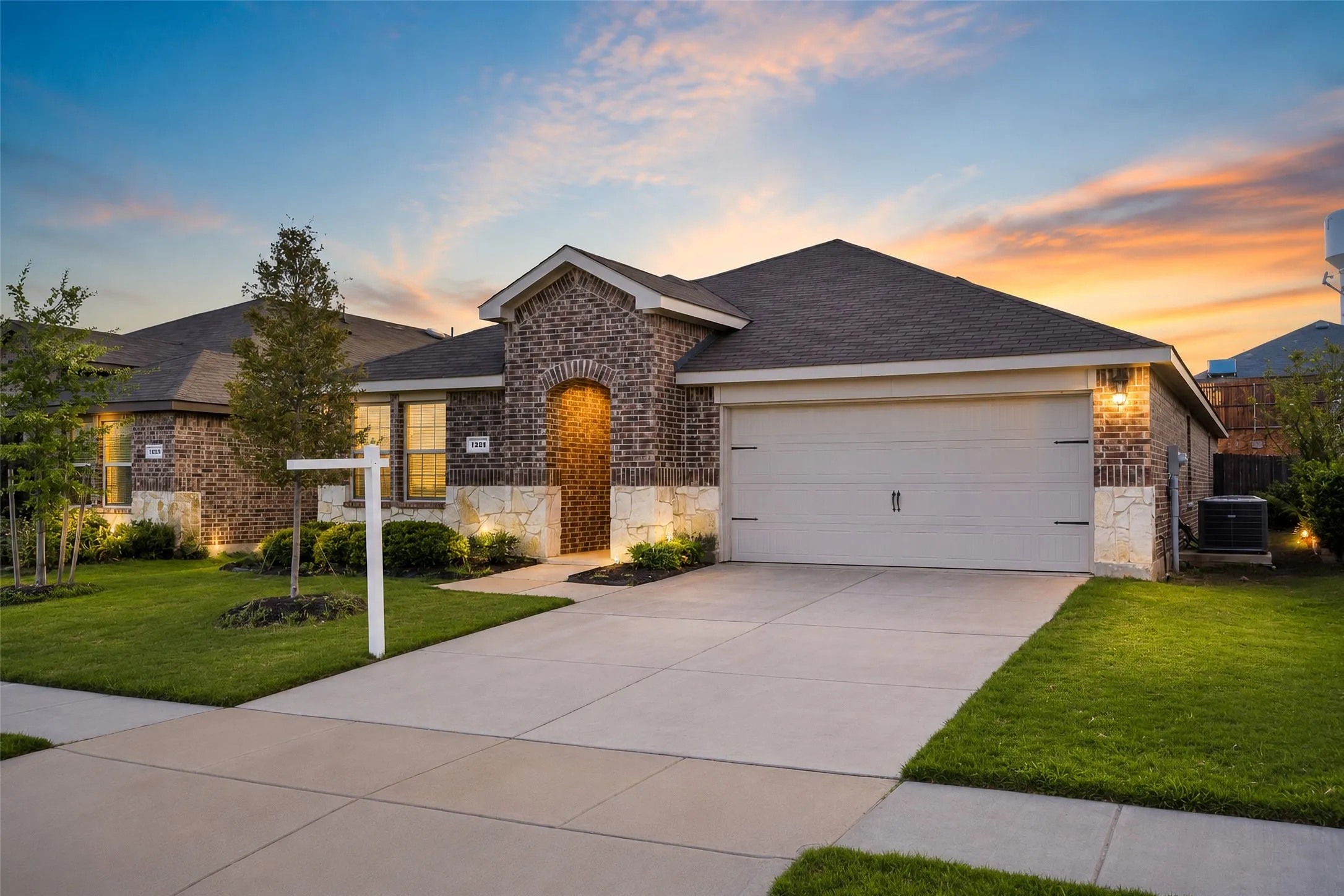 Brick and stone veneer exterior with dark shingle roofing