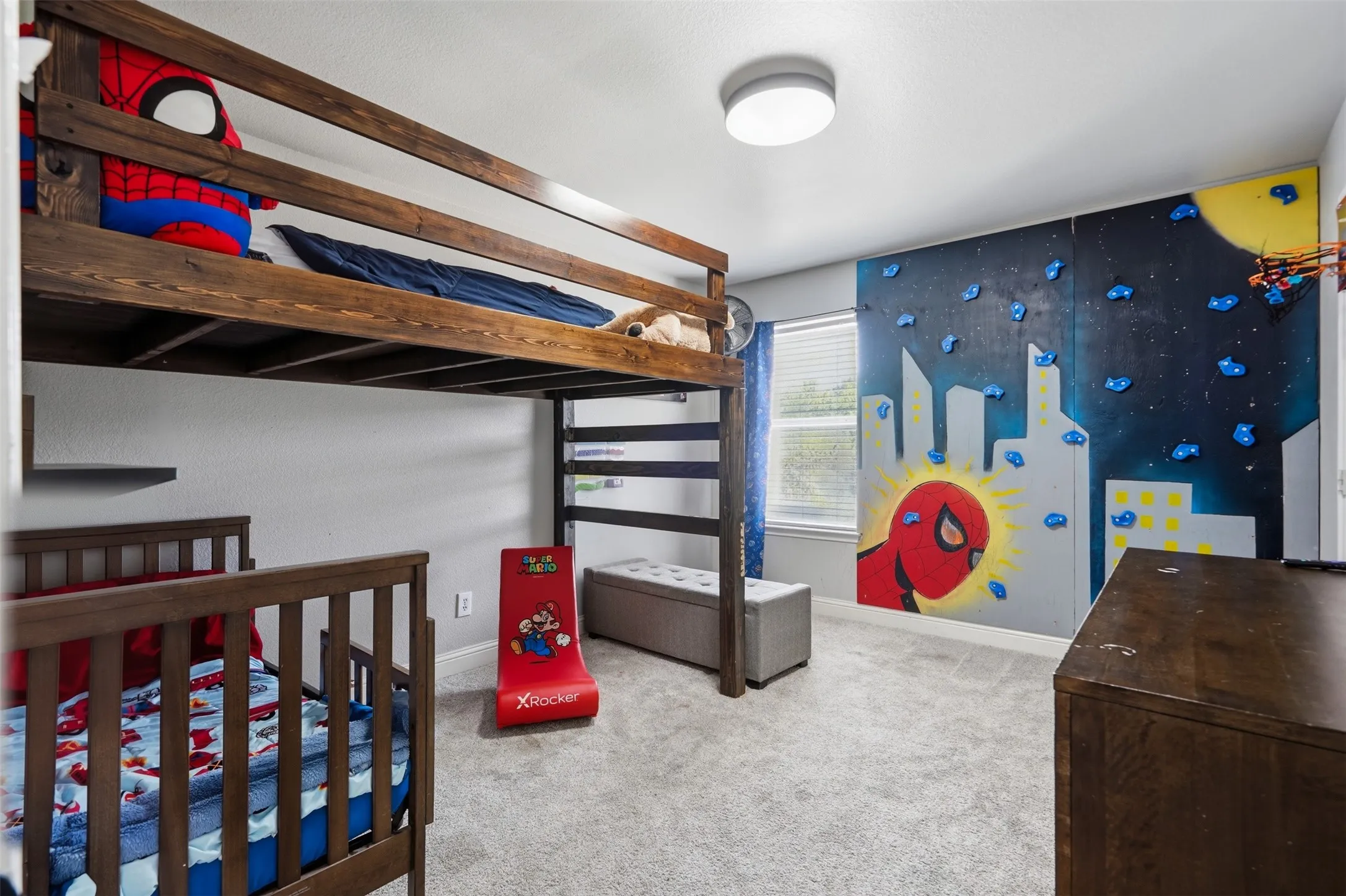 Room featuring light gray walls, gray carpet flooring, a dark wood-finish built-in bunk bed, and a built-in wall-mounted climbing feature