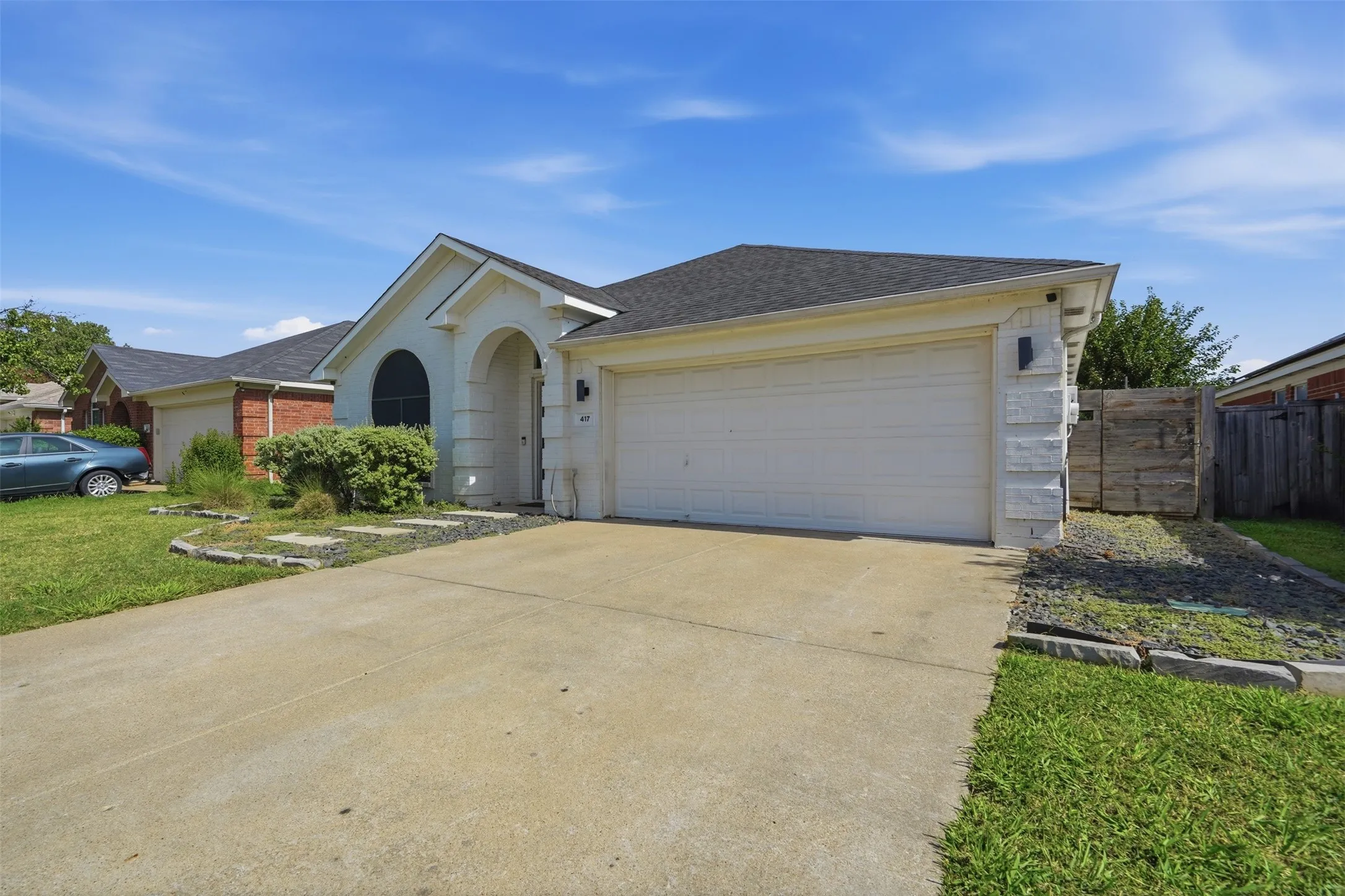 Single-story stucco exterior with an arched entryway