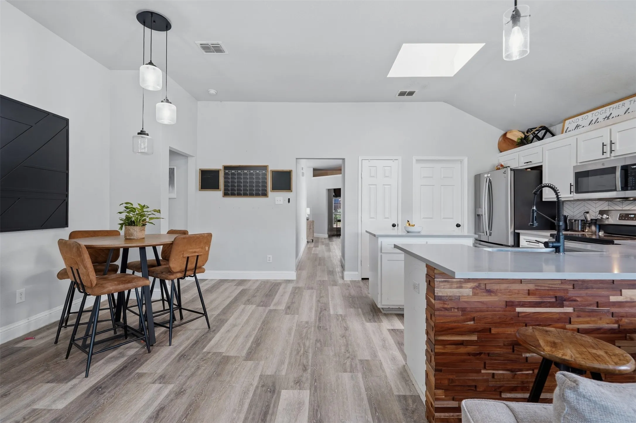 Open-concept kitchen and dining area featuring light wood-finish flooring