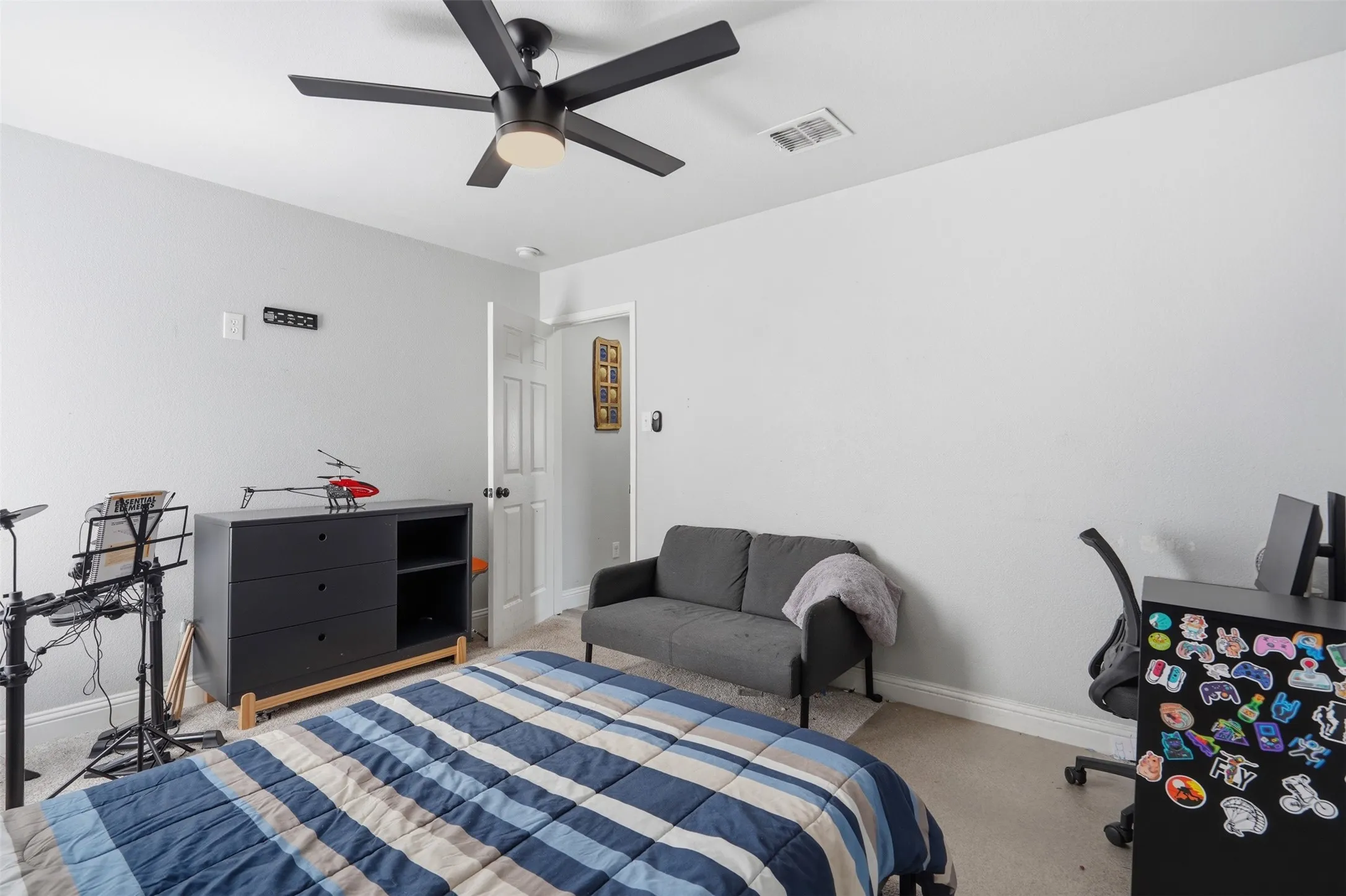 Neutral wall colors complement the light-toned carpeting in this room, featuring a contemporary ceiling fan with integrated lighting