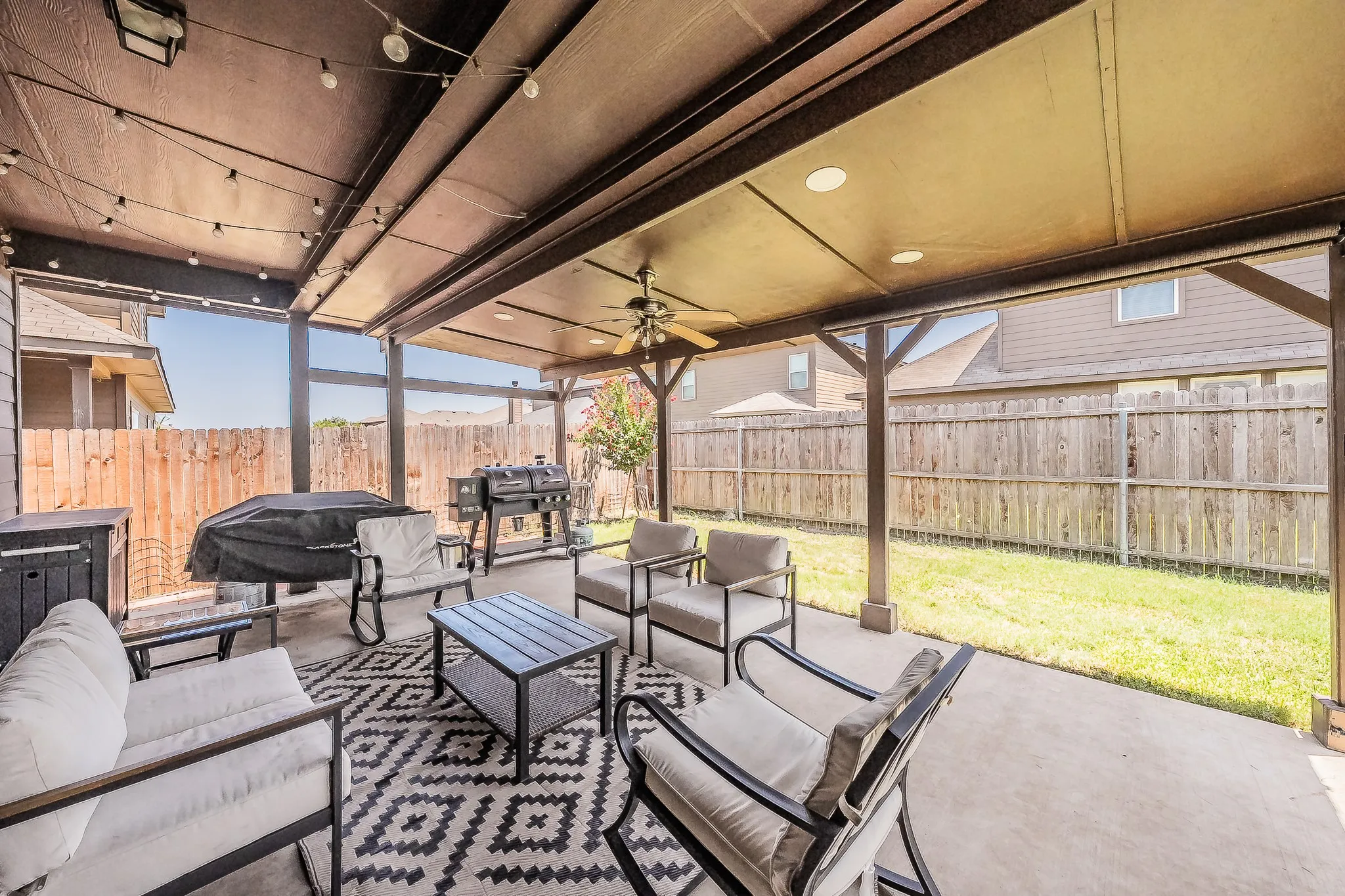 Covered patio featuring string lighting, recessed ceiling lights, and a ceiling fan.