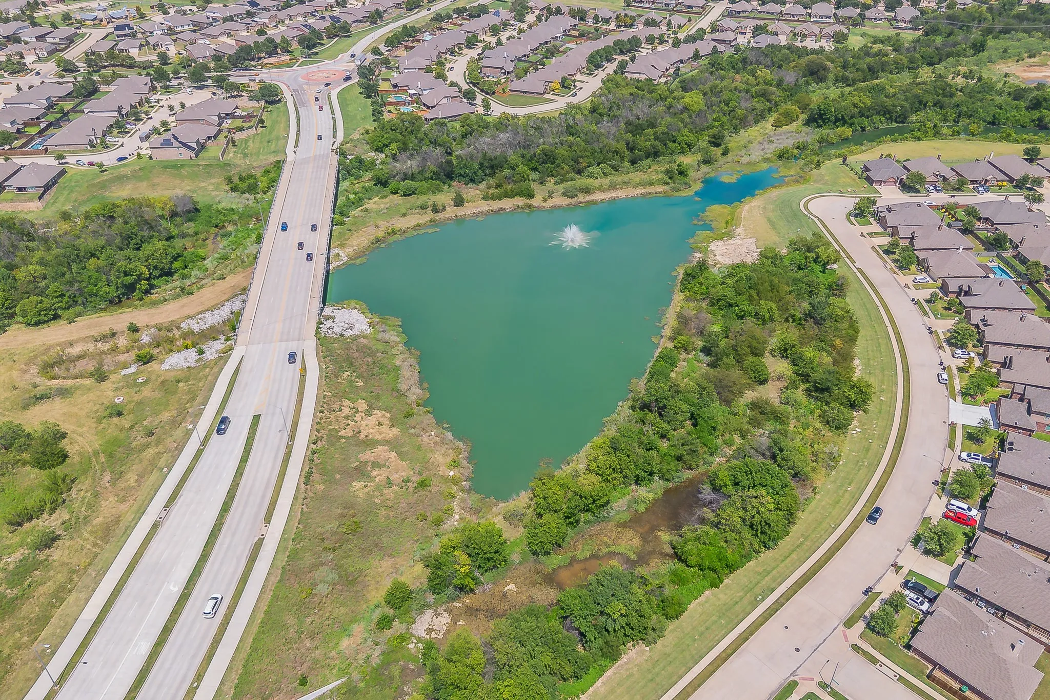 Aerial perspective showcasing a residential development spanning a body of water perfect for fishing.