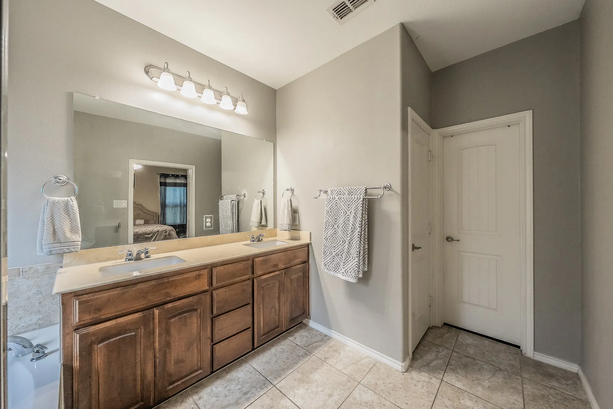 Double vanity with a light-toned granite countertop and integrated sinks