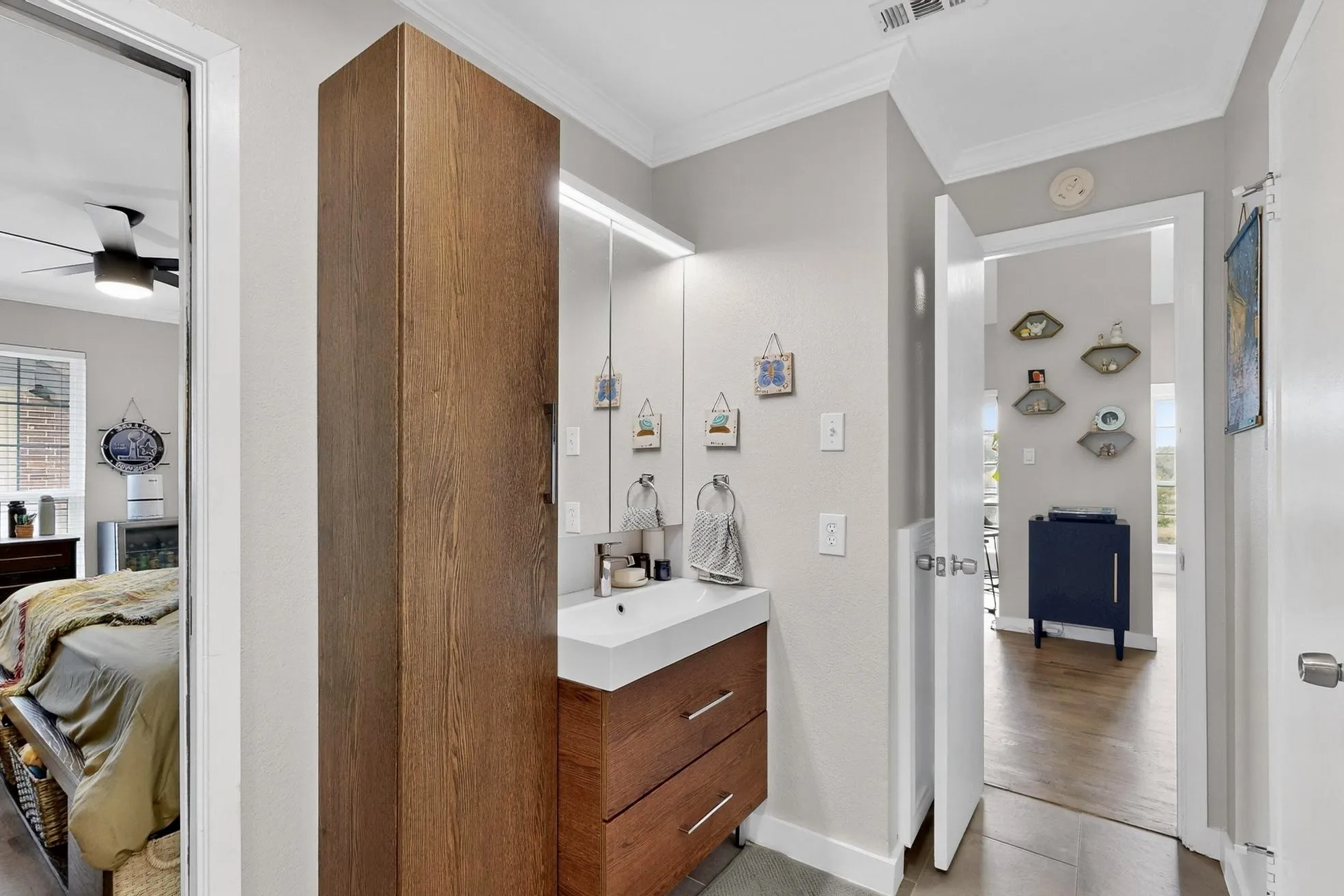 Modern bathroom vanity with integrated sink, wood-finish cabinetry, and vertical storage tower