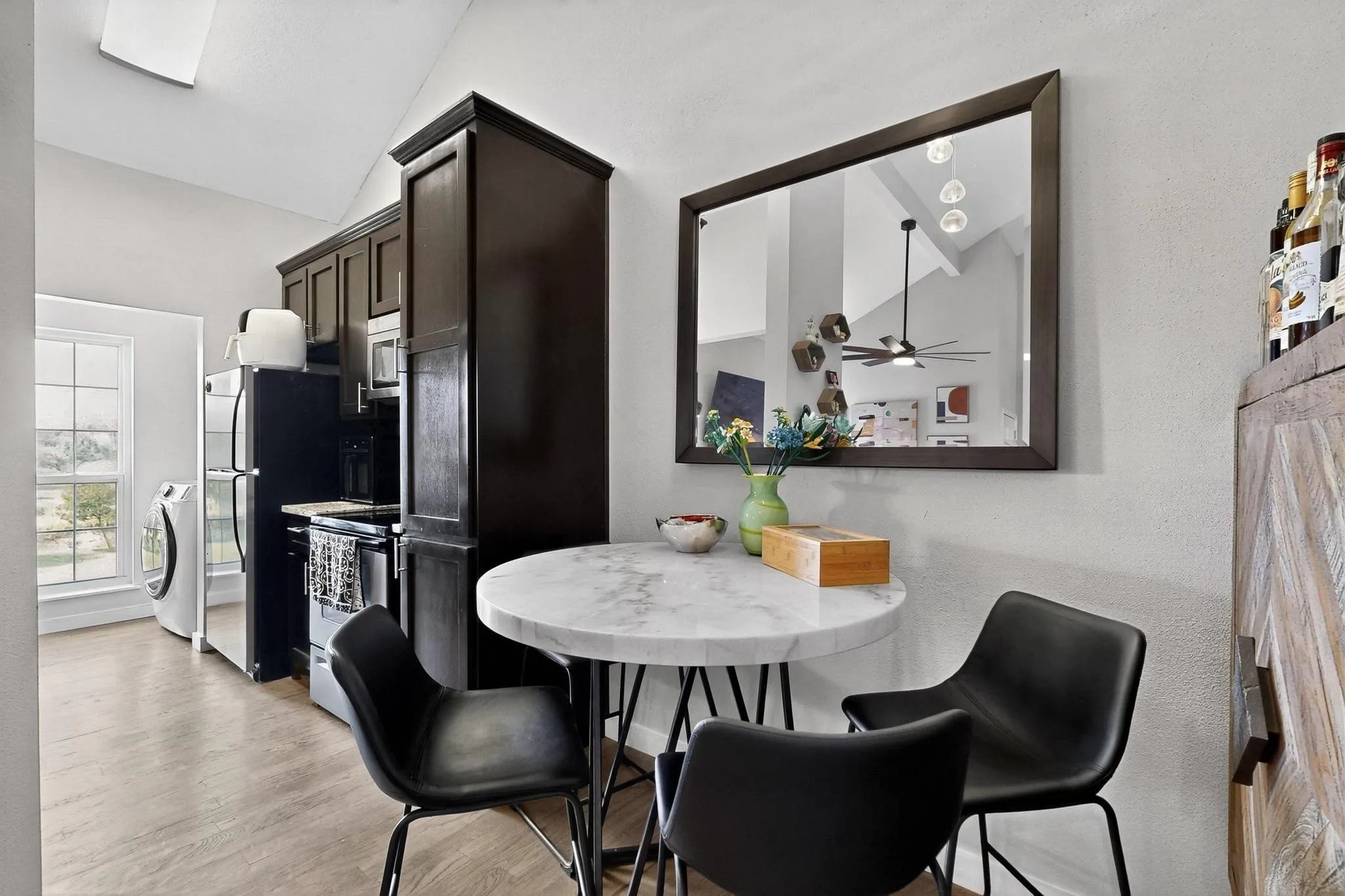 Kitchen area featuring dark wood cabinetry, integrated appliances, and wood-finish flooring