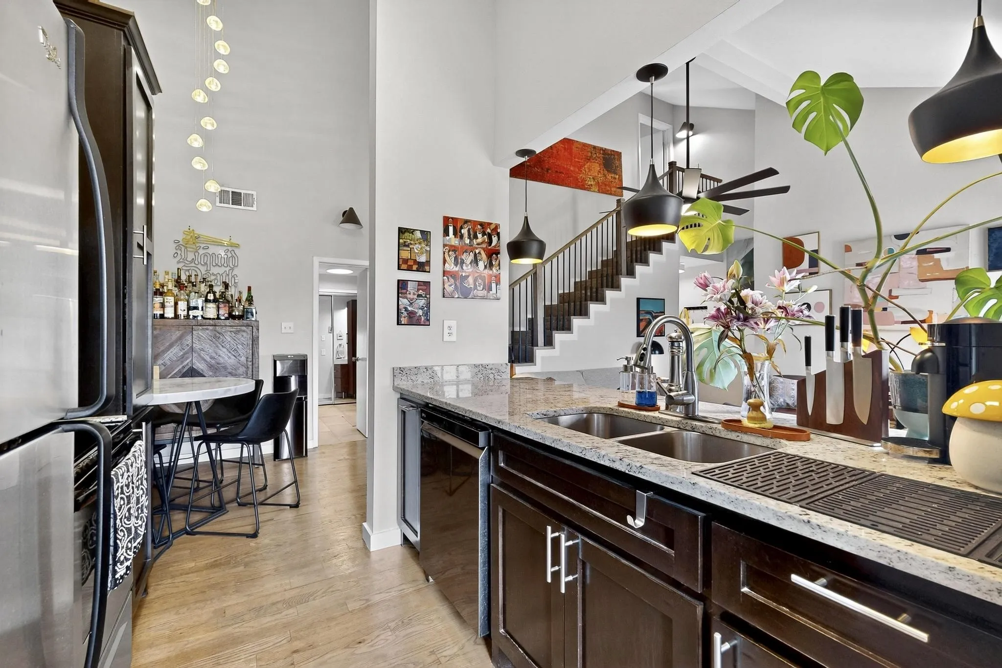 Kitchen featuring a double stainless steel sink, granite countertops, and dark wood cabinetry