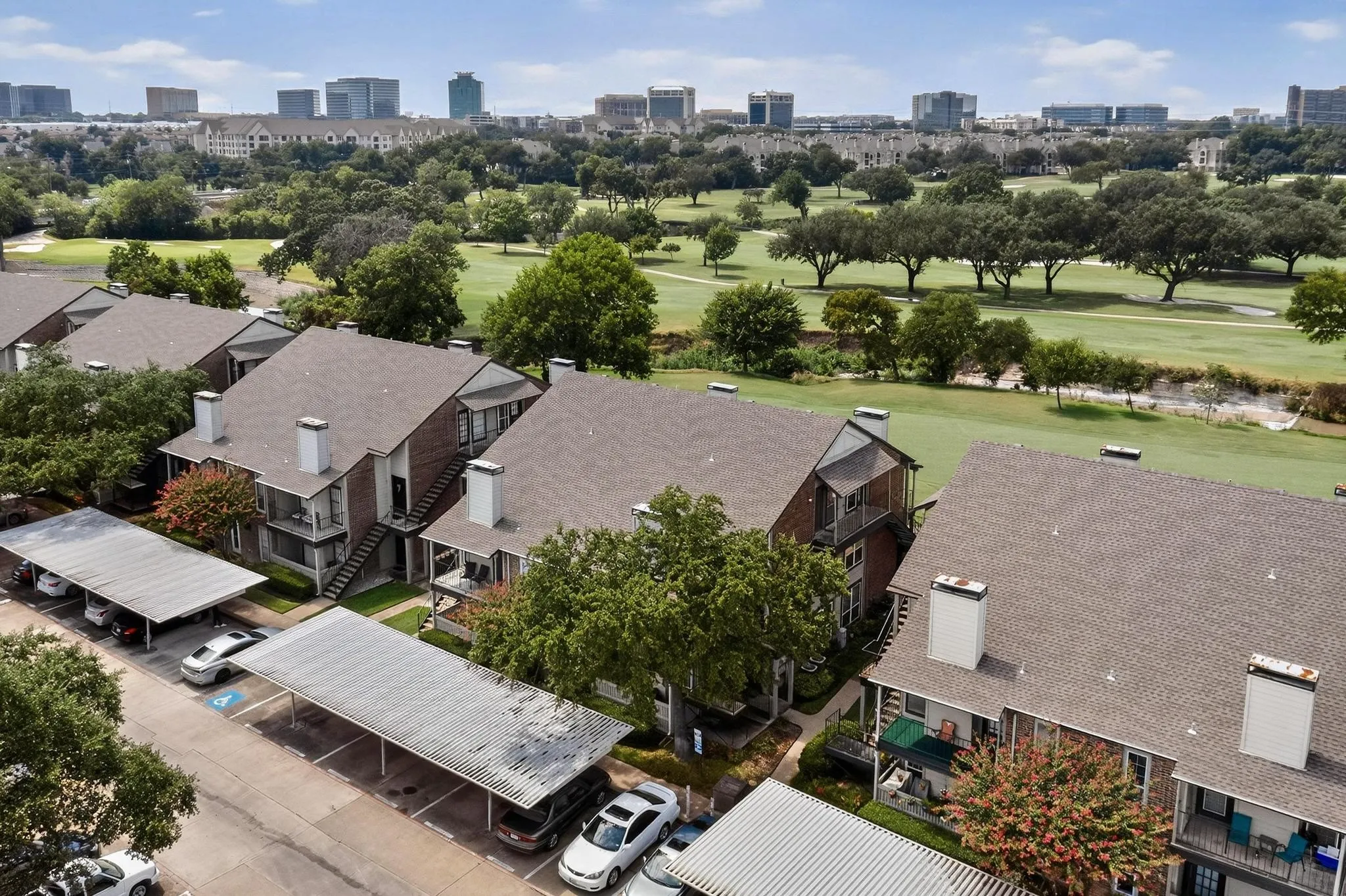 Residential complex featuring multiple buildings with brick exteriors and covered carports