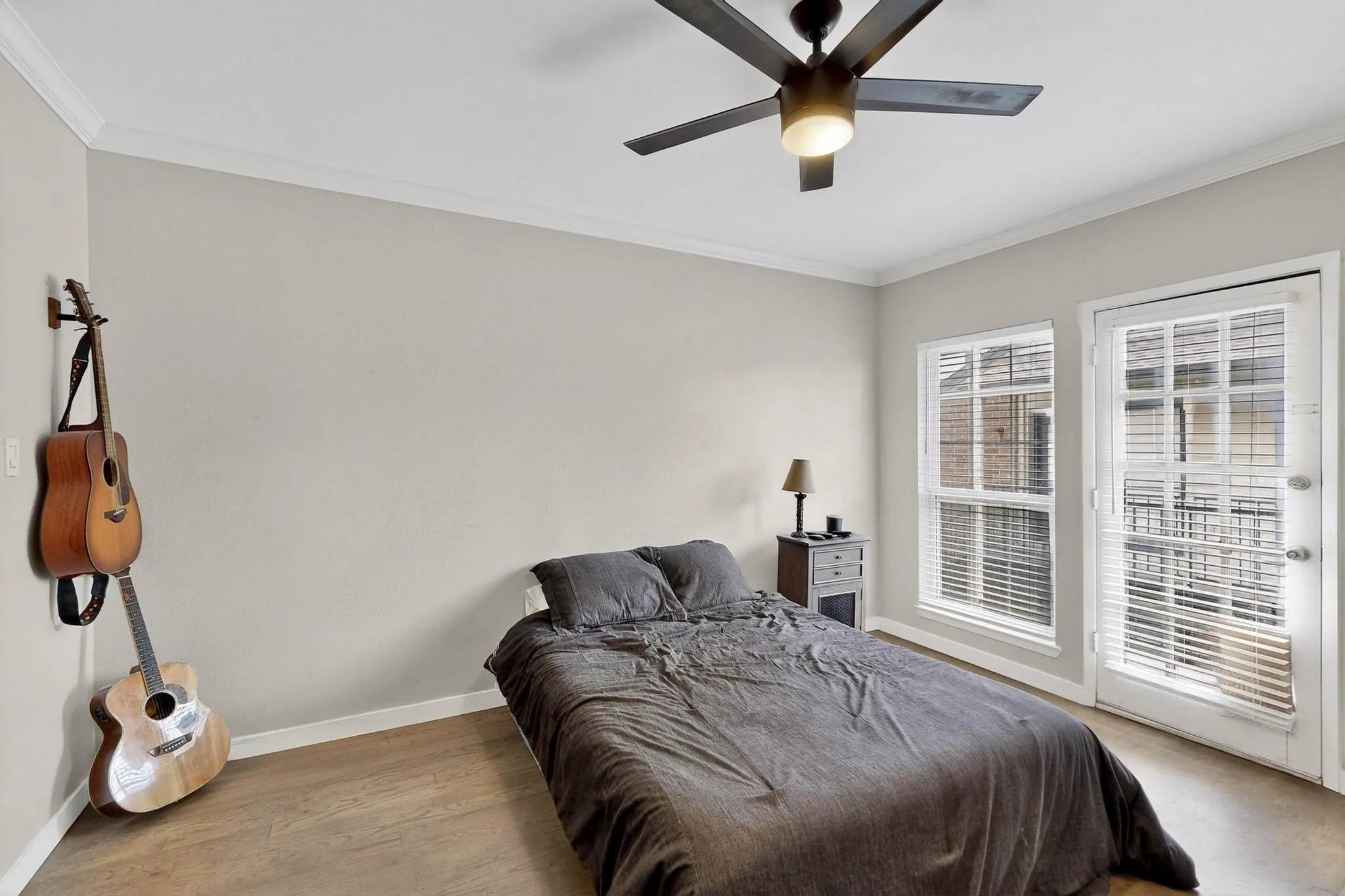 Interior room featuring wood-finish flooring, a contemporary ceiling fan with integrated lighting, and crown molding