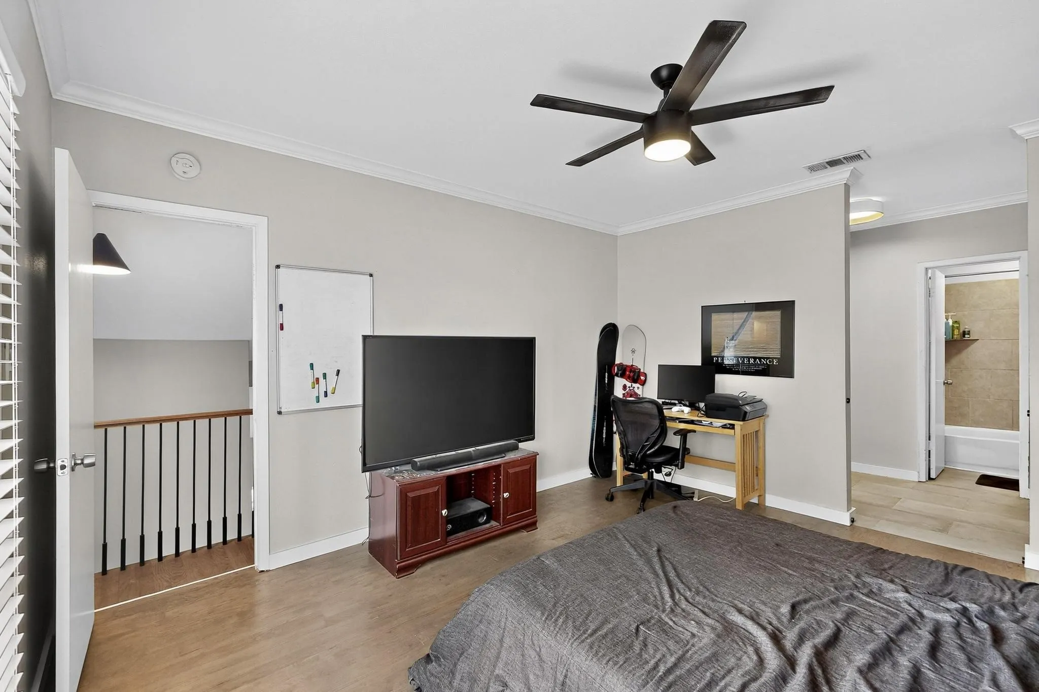 Bedroom featuring light wood-finish flooring, a modern ceiling fan with integrated lighting, and crown molding