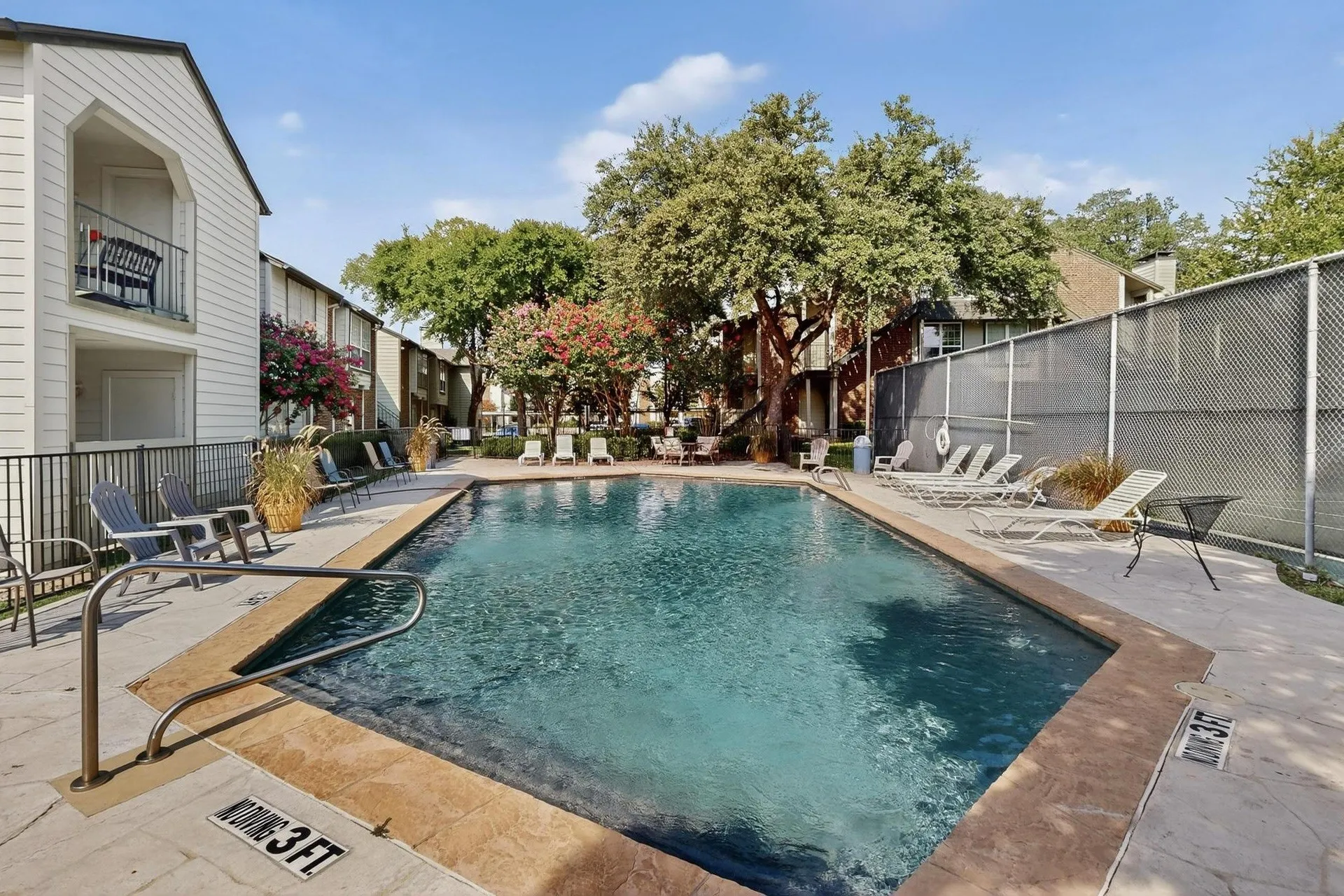 Rectangular swimming pool surrounded by a textured concrete deck