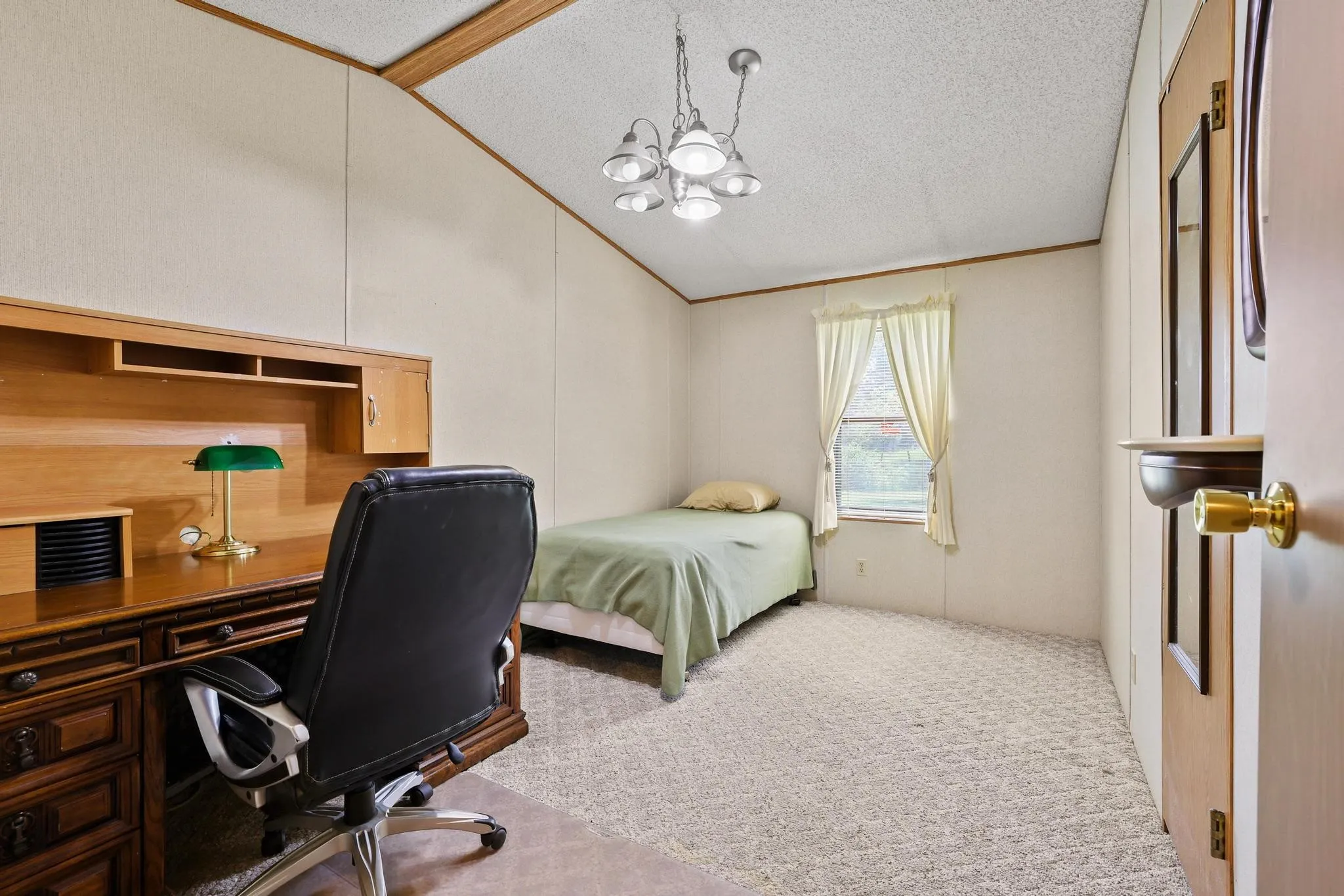 Room featuring a vaulted ceiling, textured wall panels, and light-toned patterned carpeting