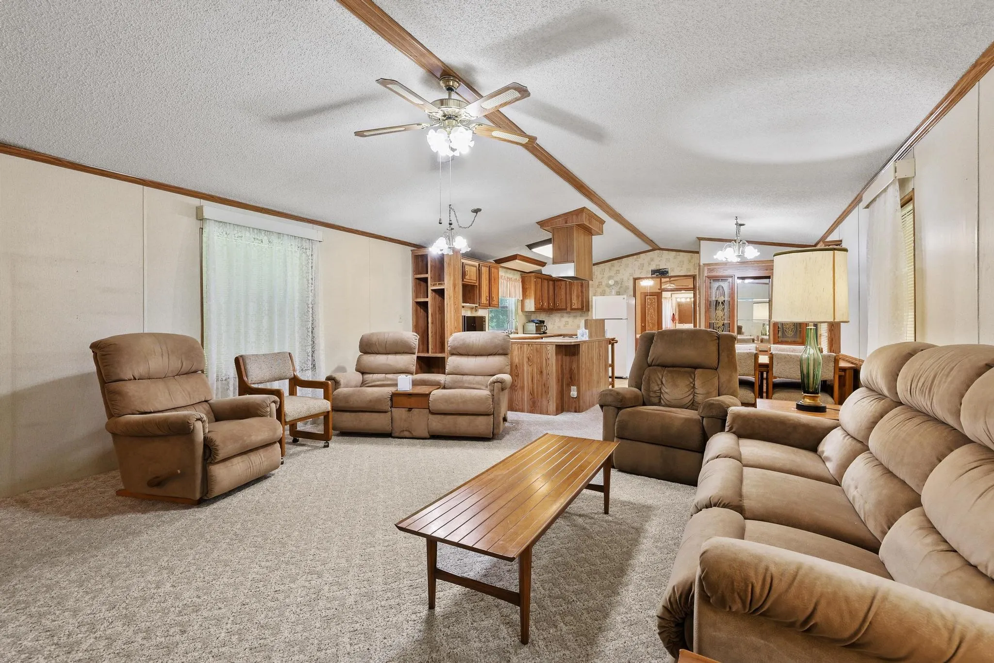Living area featuring carpet flooring and a ceiling fan with integrated lighting
