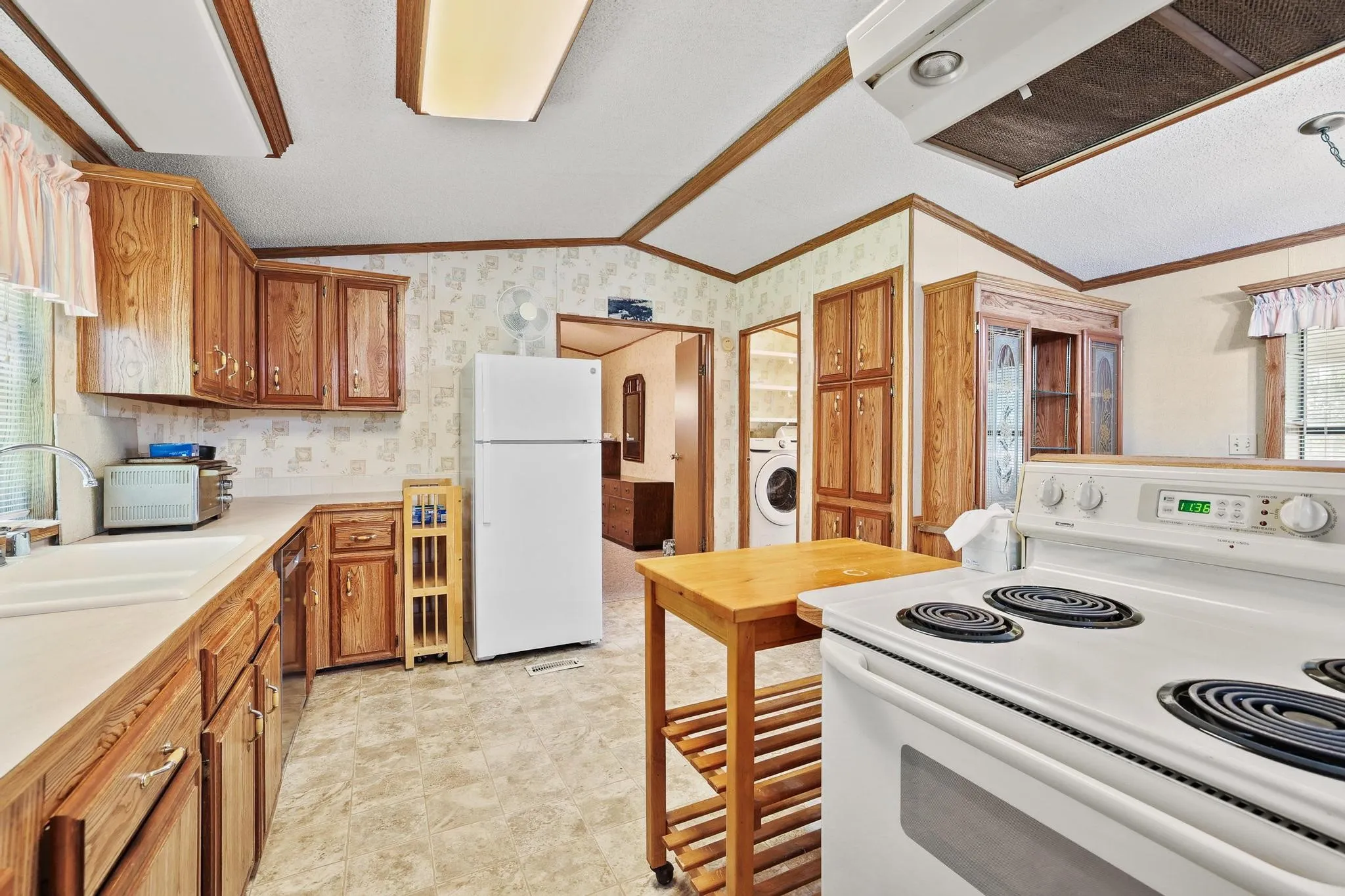 Kitchen featuring wood cabinetry, white countertops, a white electric range, and a white refrigerator