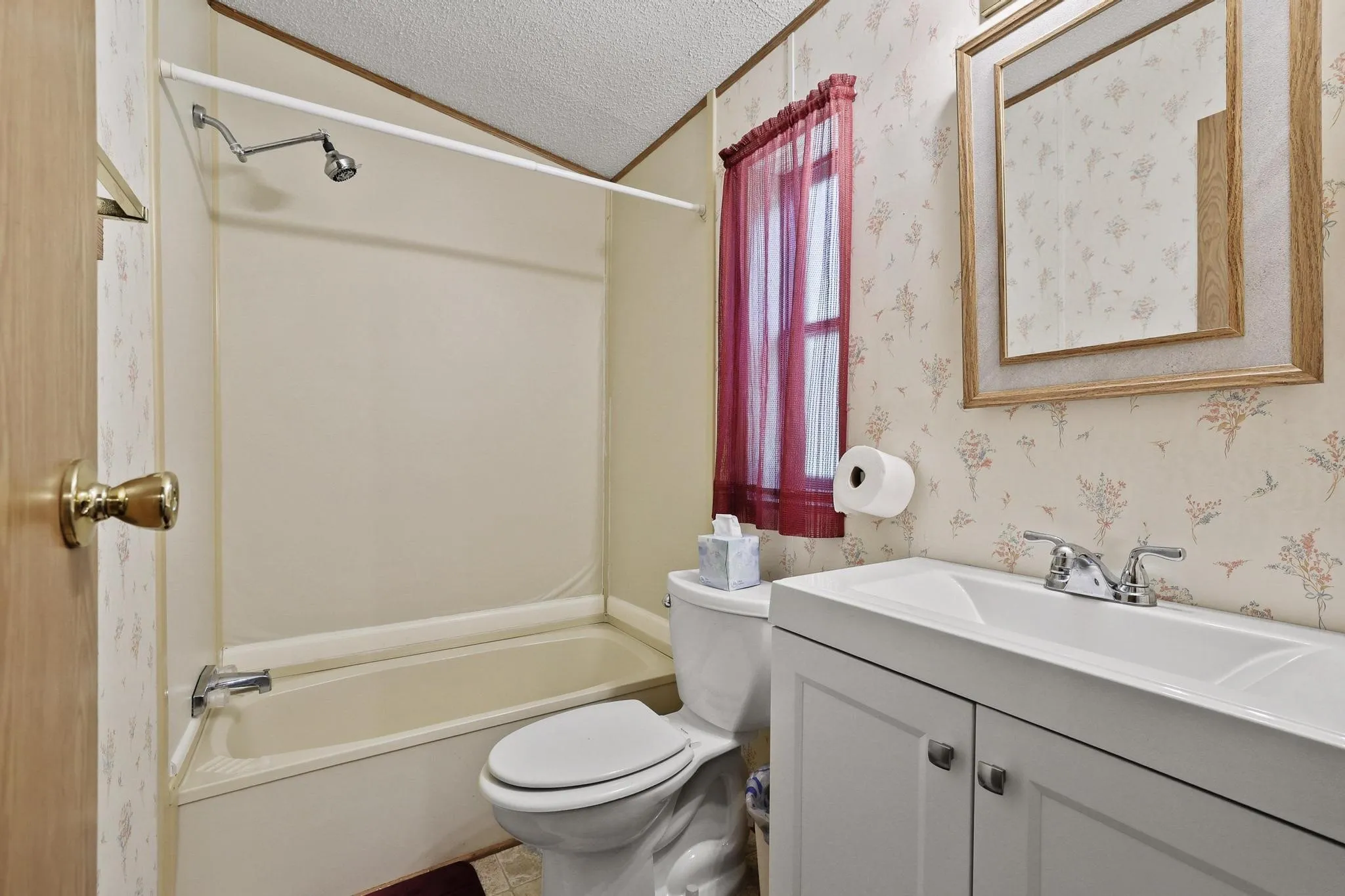 Bathroom featuring a white vanity with integrated sink, chrome faucet, and a framed mirror