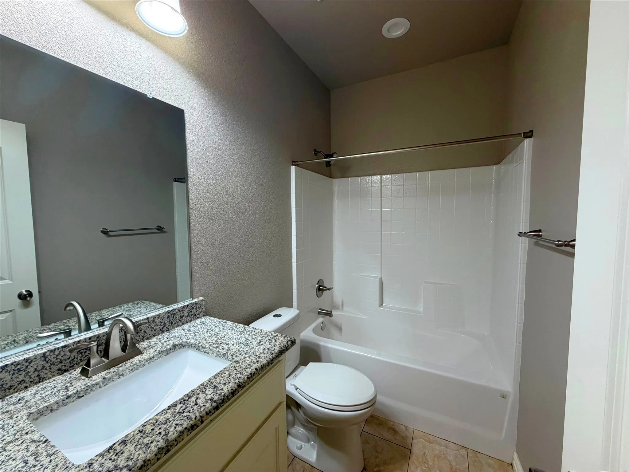 Bathroom featuring a vanity with granite countertop, integrated sink, and brushed nickel faucet