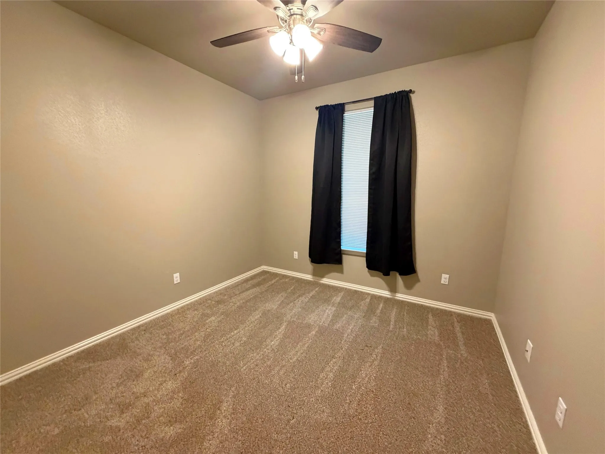 Room featuring neutral-toned walls, patterned carpeting, and white trim