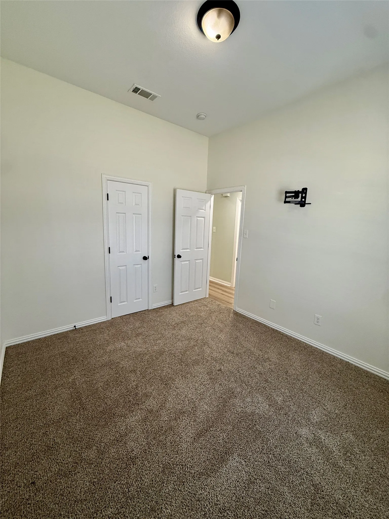 Carpeted interior space featuring light-colored walls and white trim
