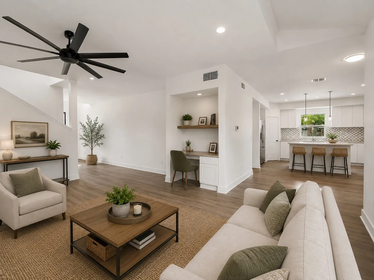 Open-concept living area featuring wood-finish flooring, recessed lighting, and a built-in desk with shelving